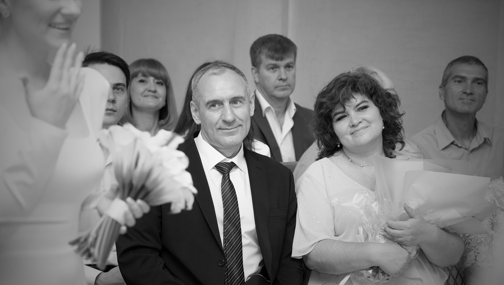 черно белое свадебное фото где родственники и друзья смотрят на невесту 