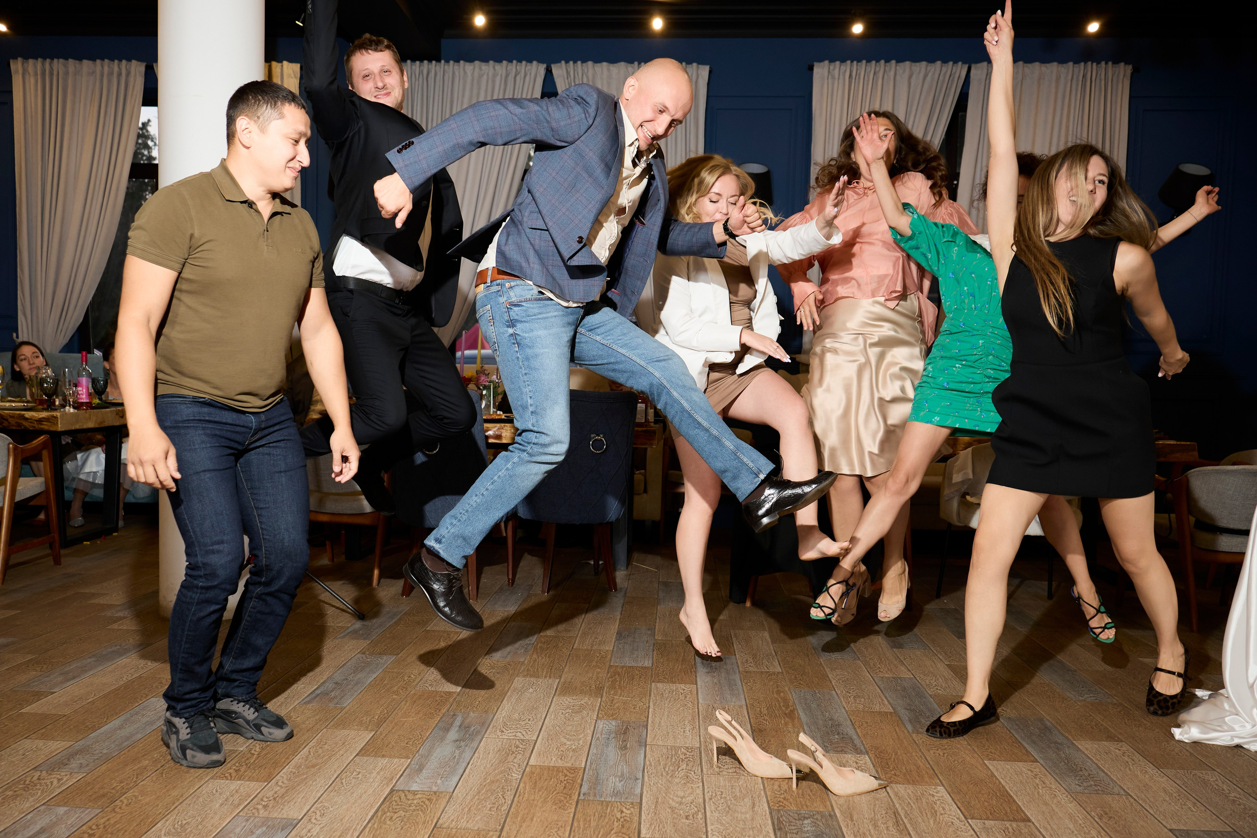 Фото прыгающих друзей на банкете в ресторане.