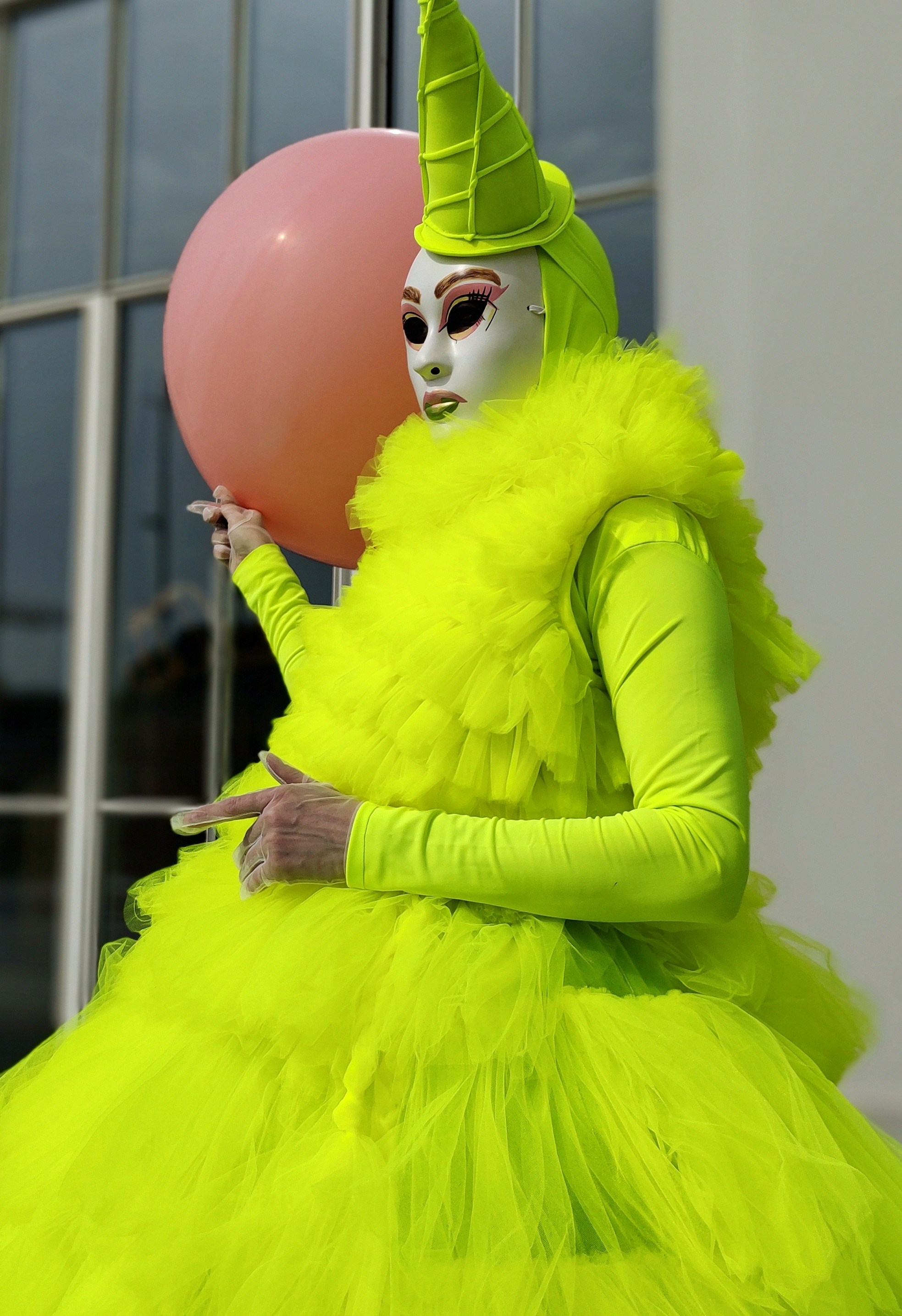 Артист в салатовом костюме стоит у ресторана в Москве