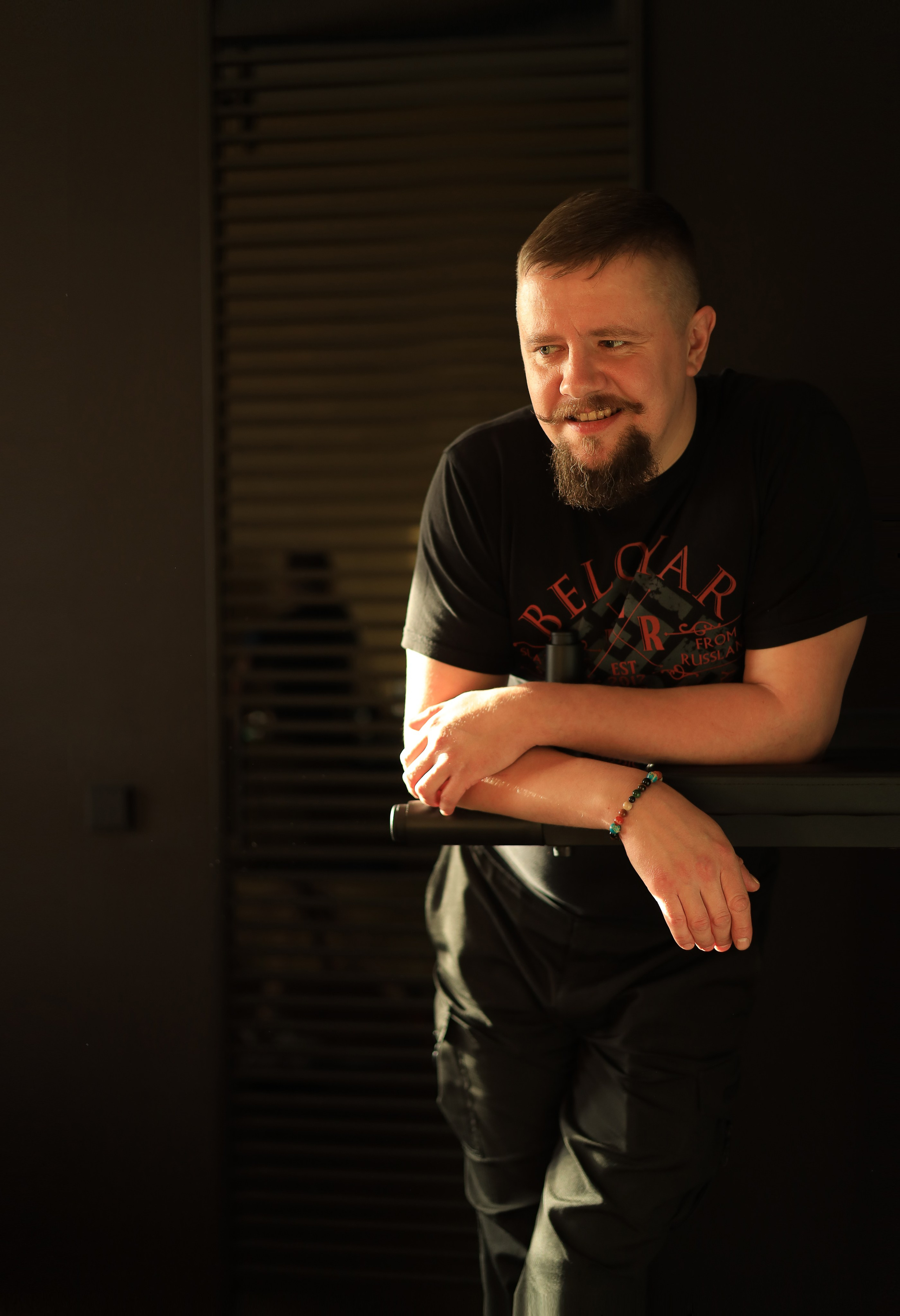 мужская фотосессия парень стоит сложив руки и смотрит вбок