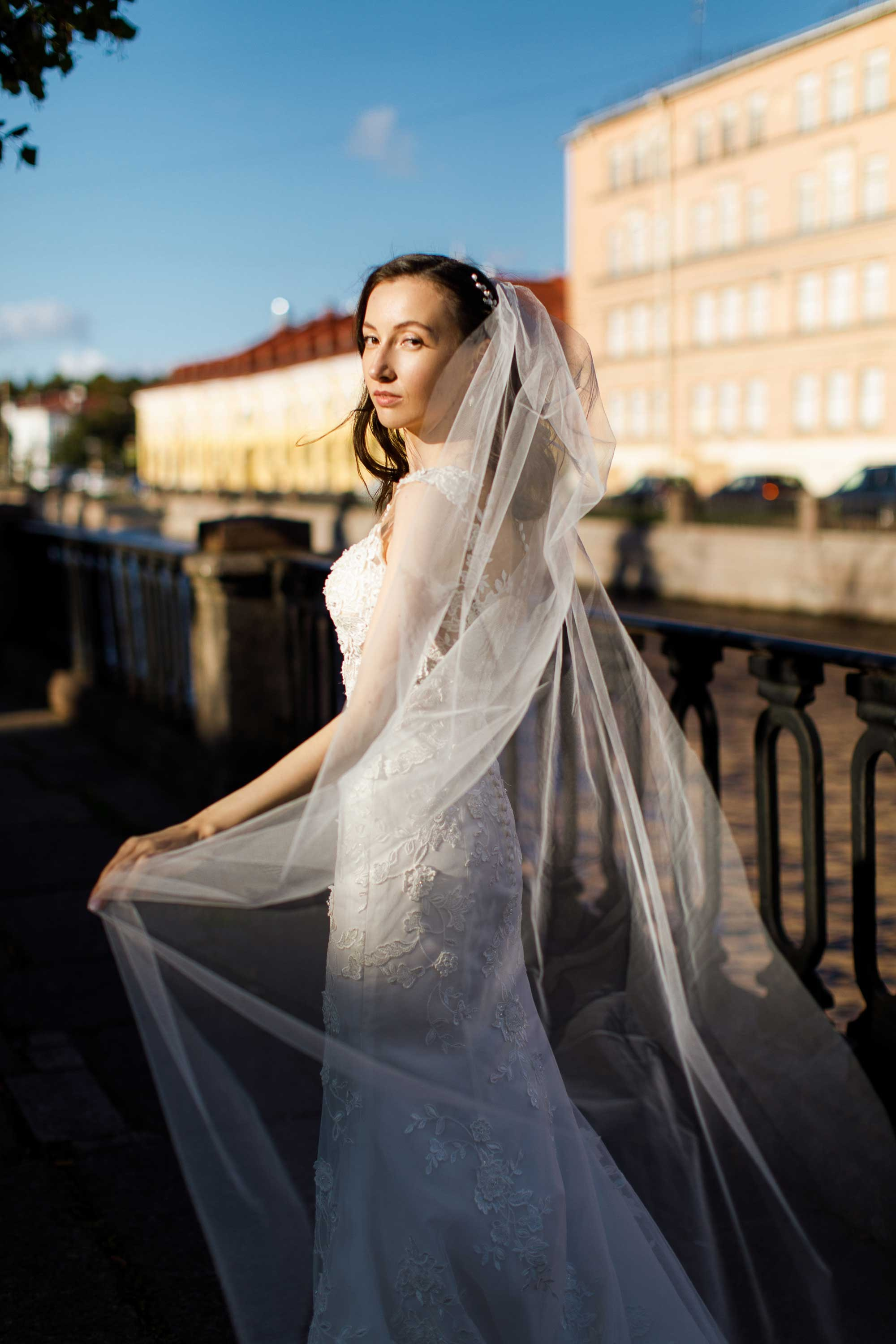 Невеста с фатой стоит на ветру