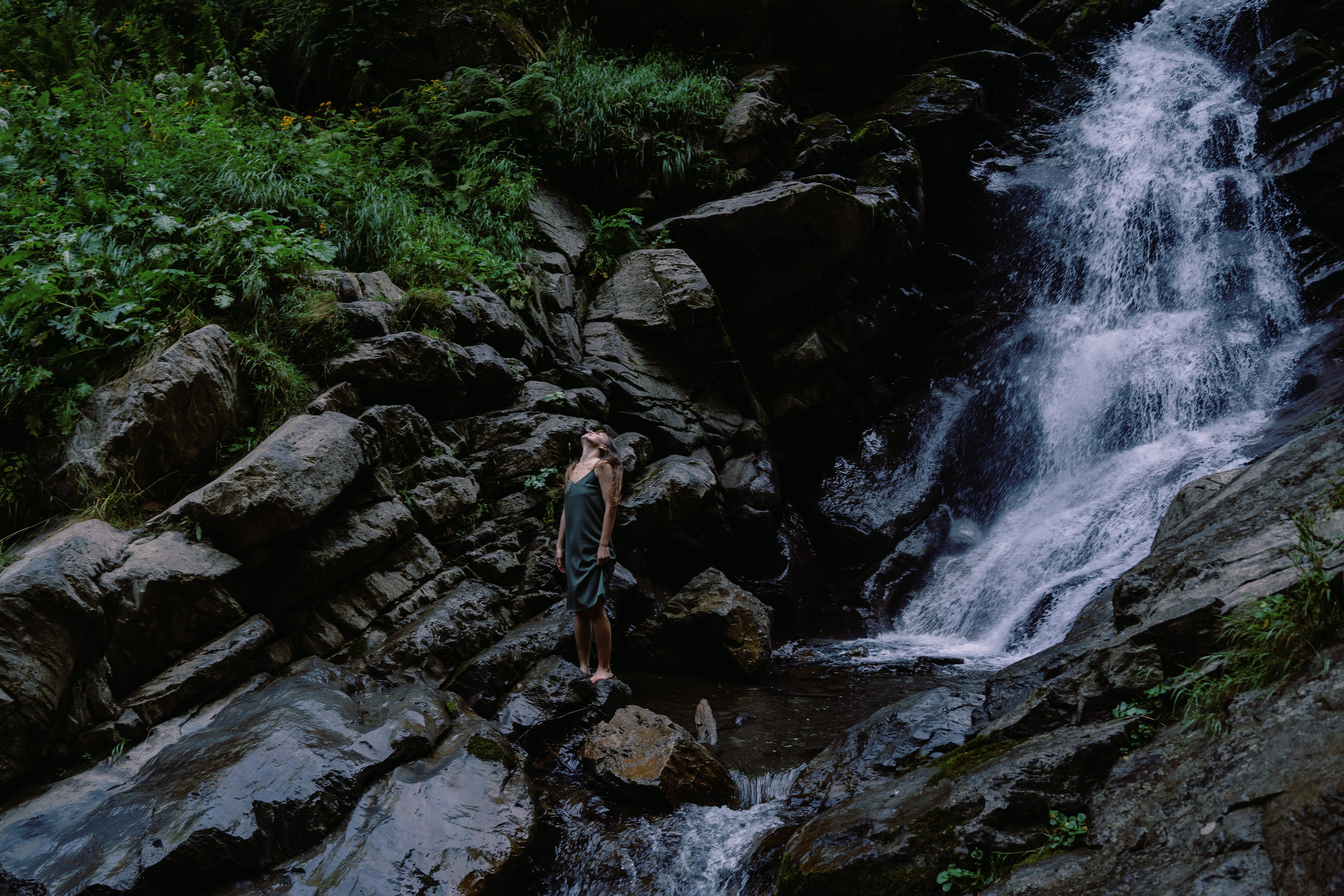 Фото общего плана девушки на фоне водопада