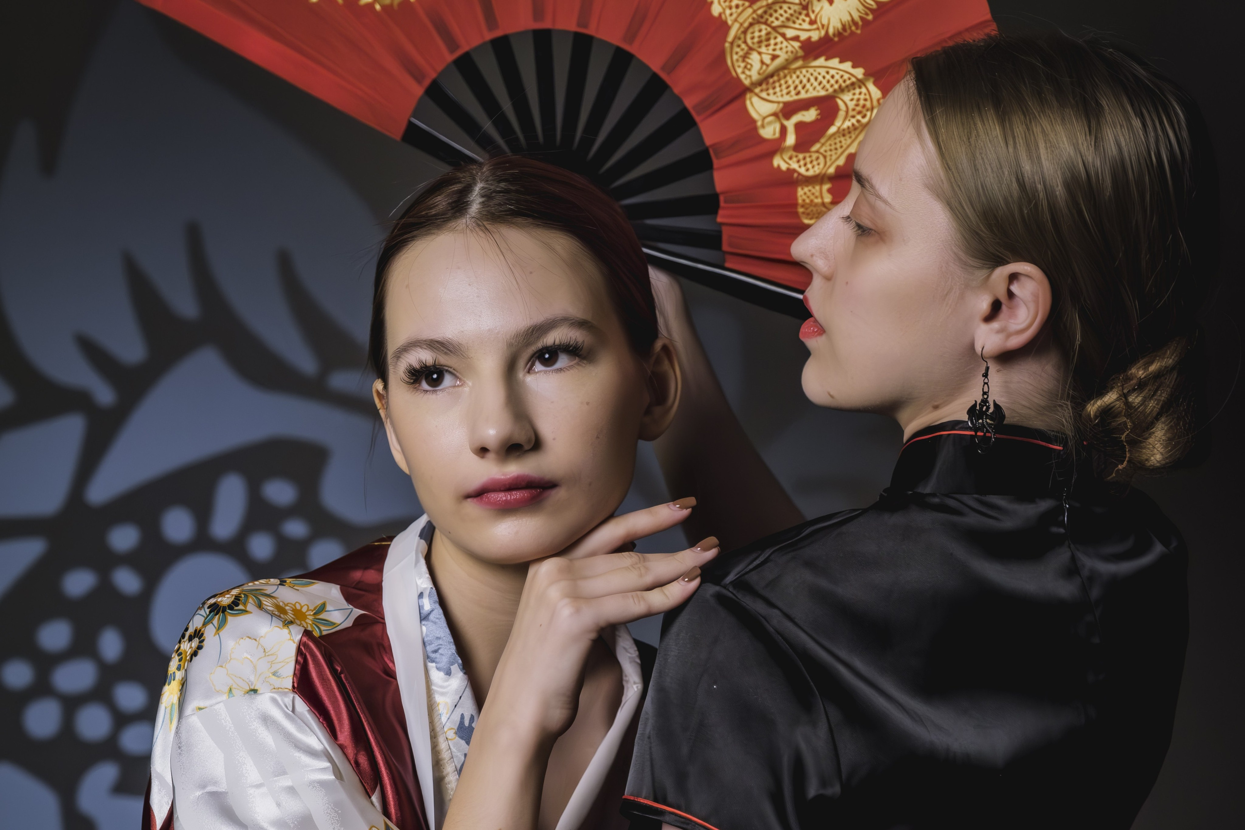 Две девушки позируют в японском стиле с веером