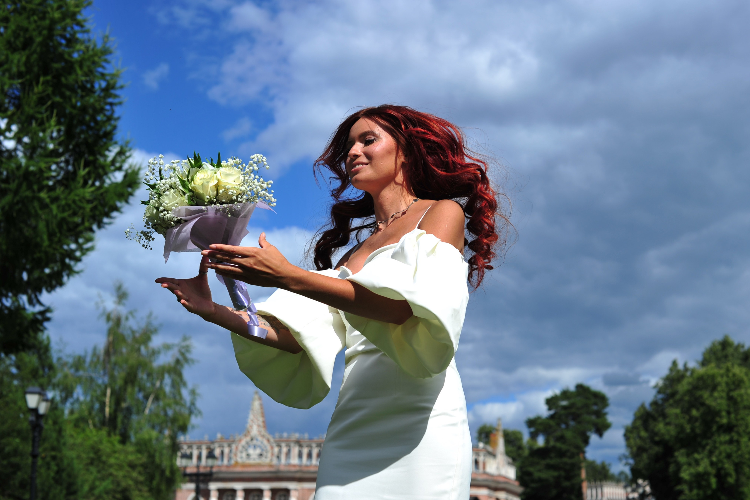 Свадьба в Царицыно летом, невеста ловит свадебный букет, волосы невесты развеваются
