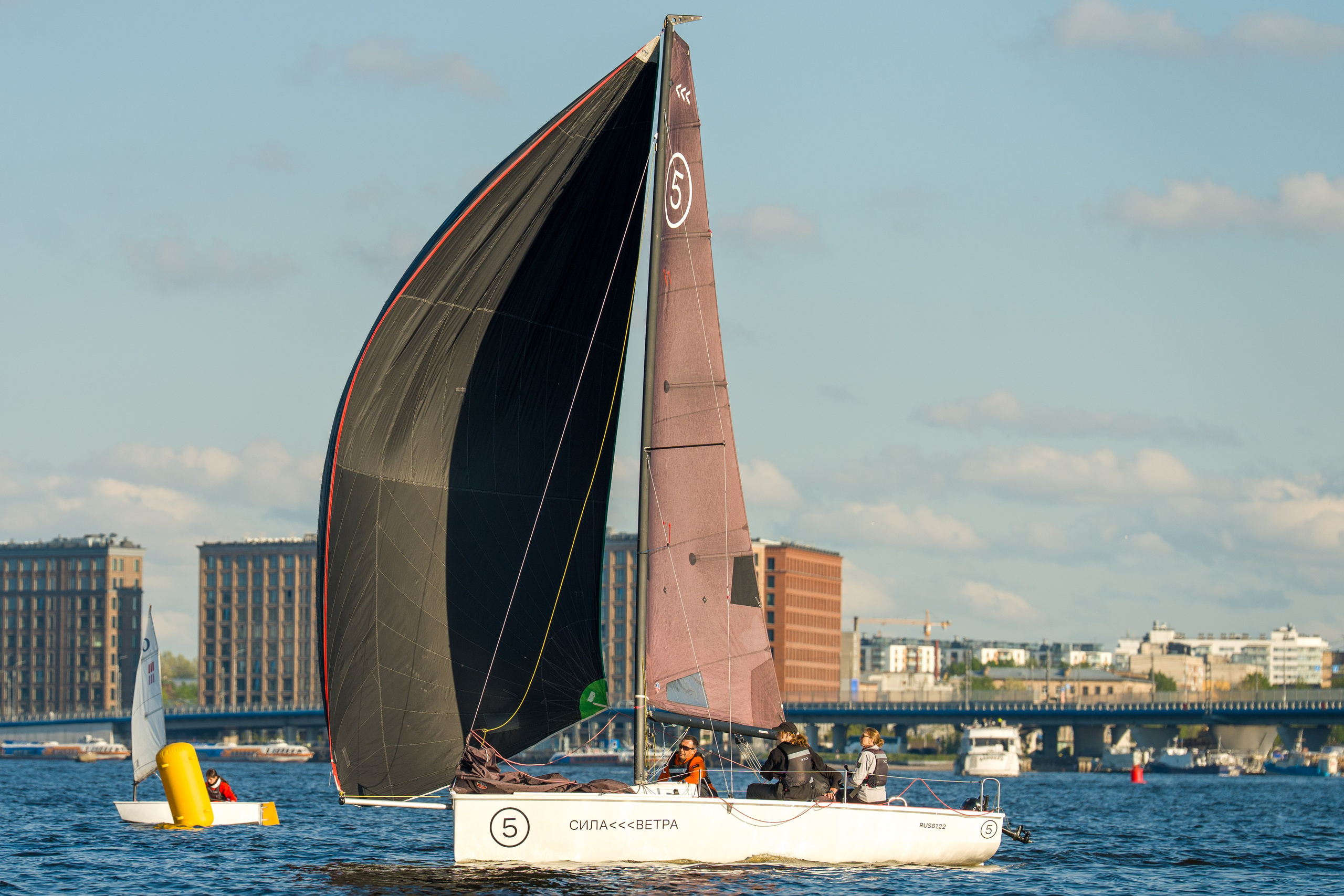 SV20 crew powers under black gennaker on the Neva, sunny breeze