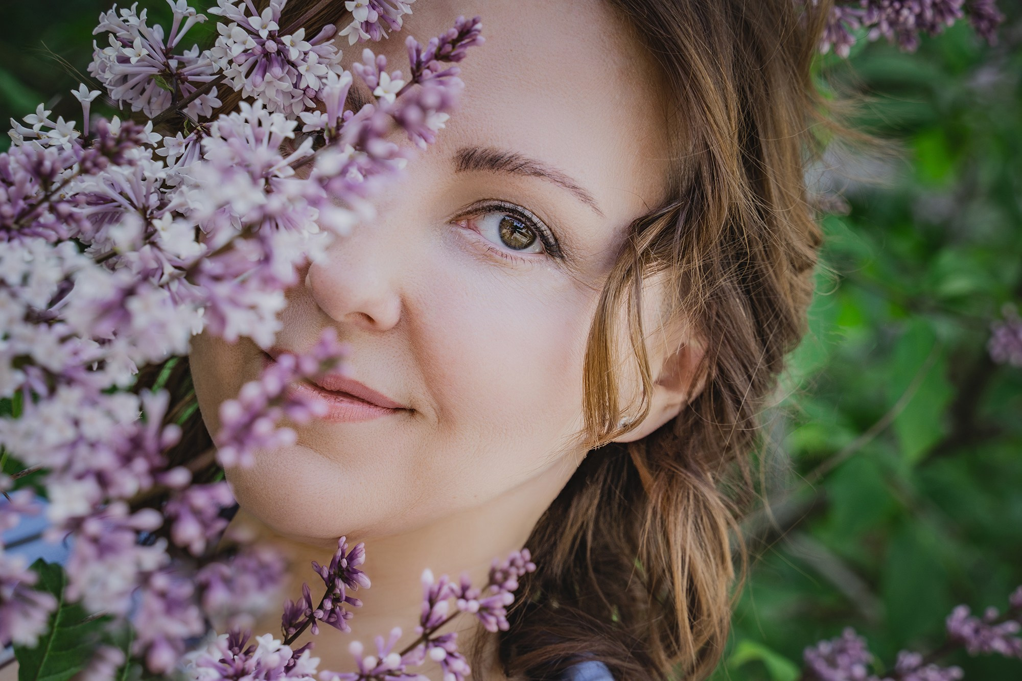 Девушка выглядывающая из-за куста сирени.