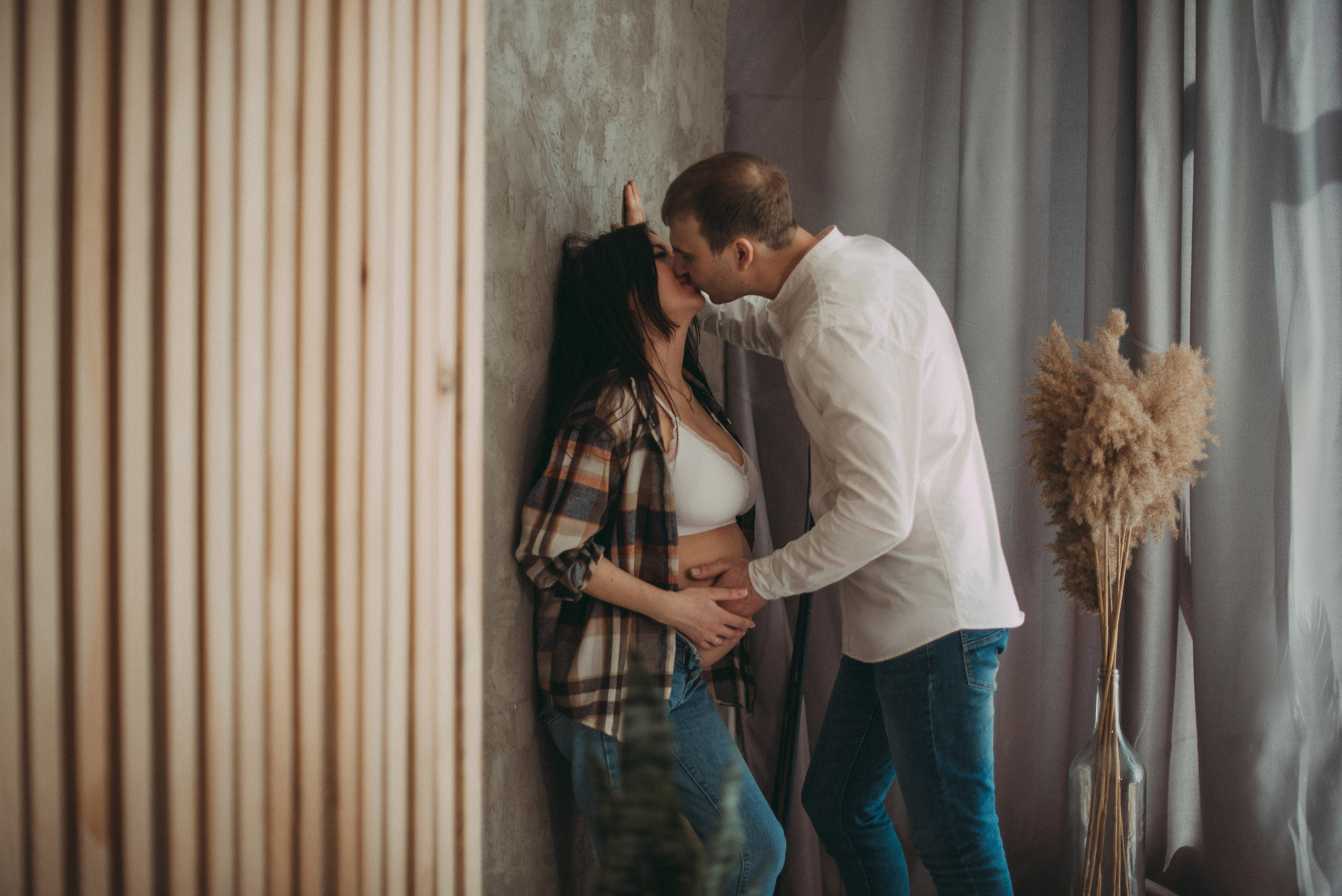 парень целует девушку на фотосессии во время беременности