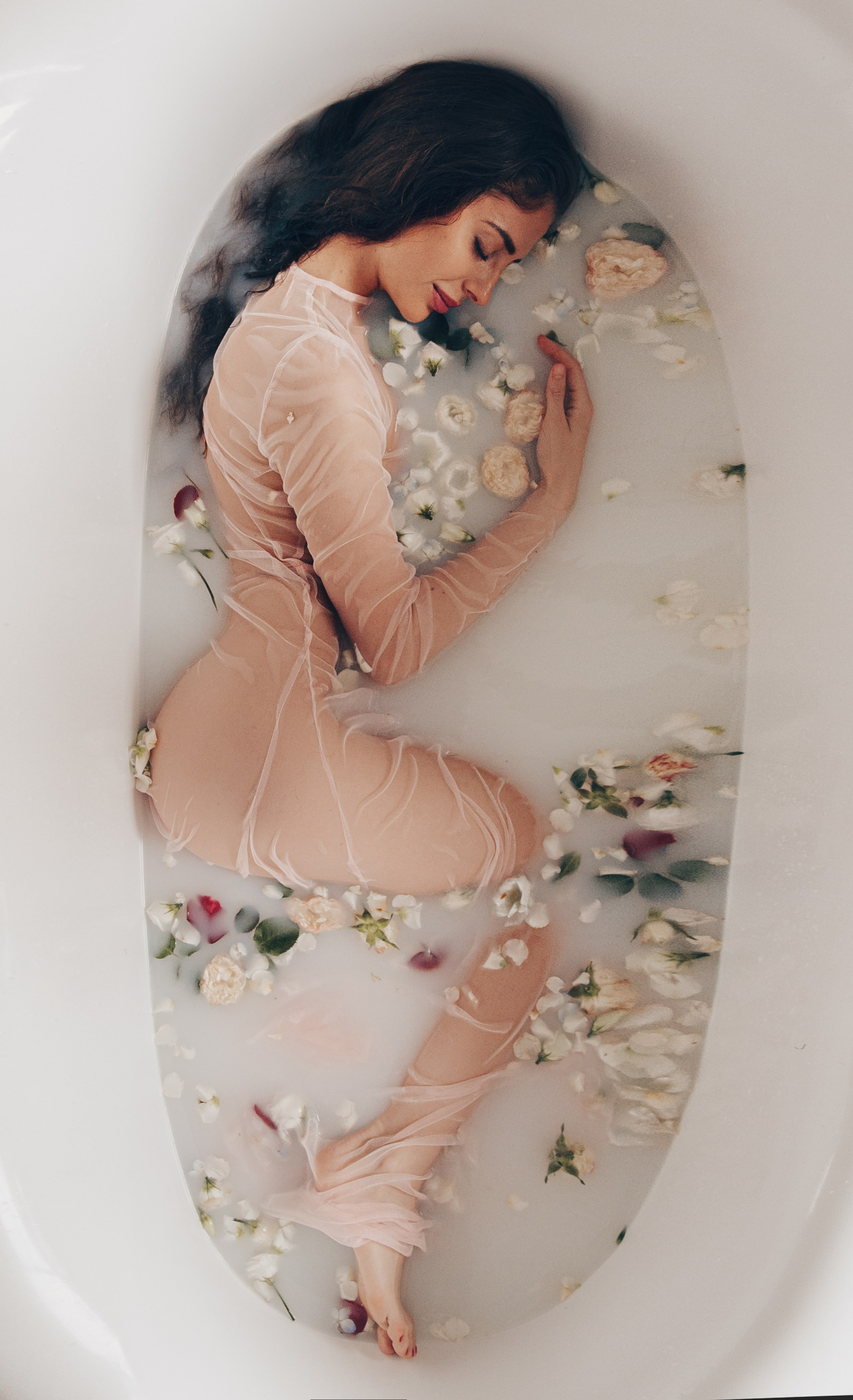 голая девушка в молочной ванне с цветами 