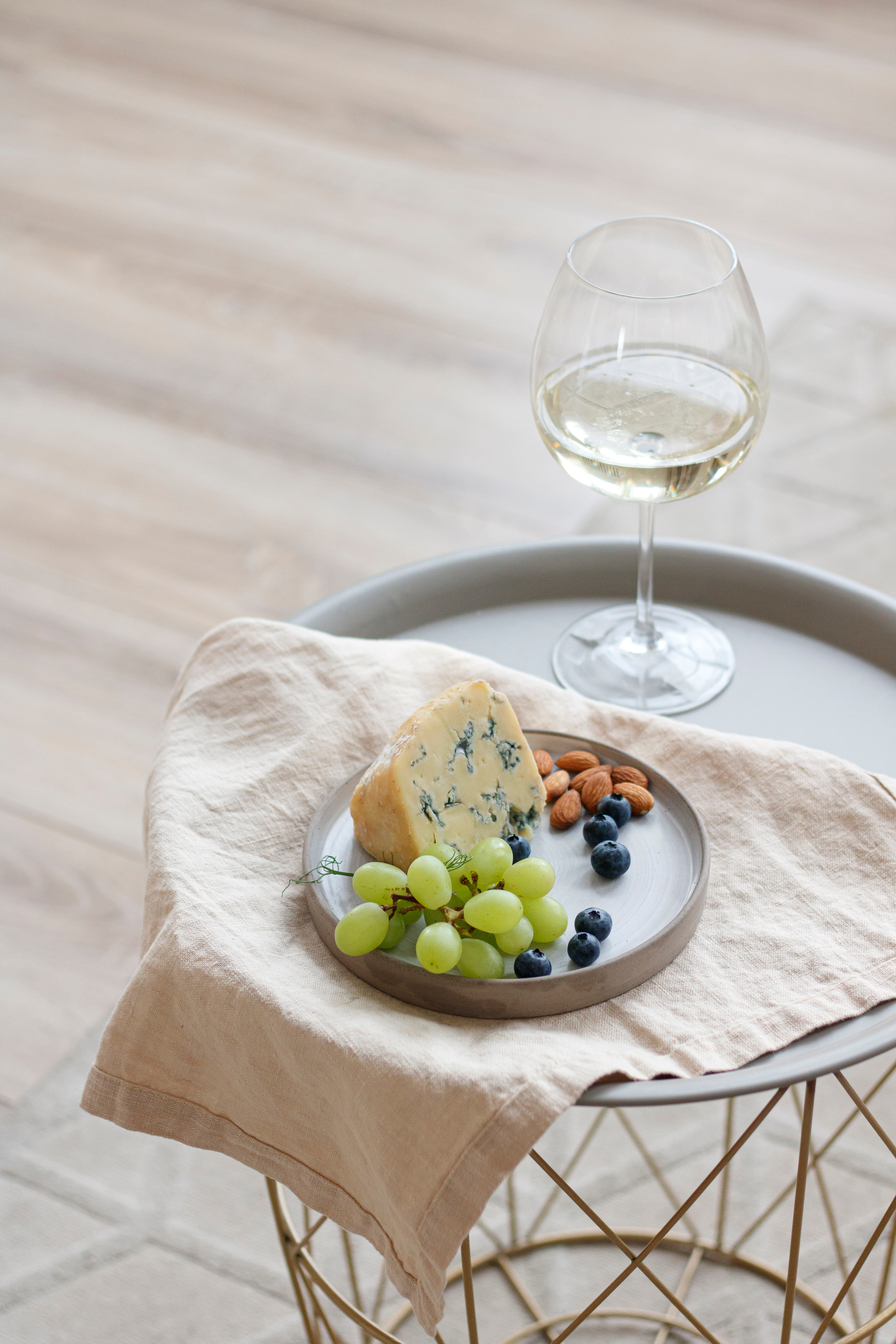 Съемка в студии продуктов и еды ассорти сыра и фруктов на столике с вином