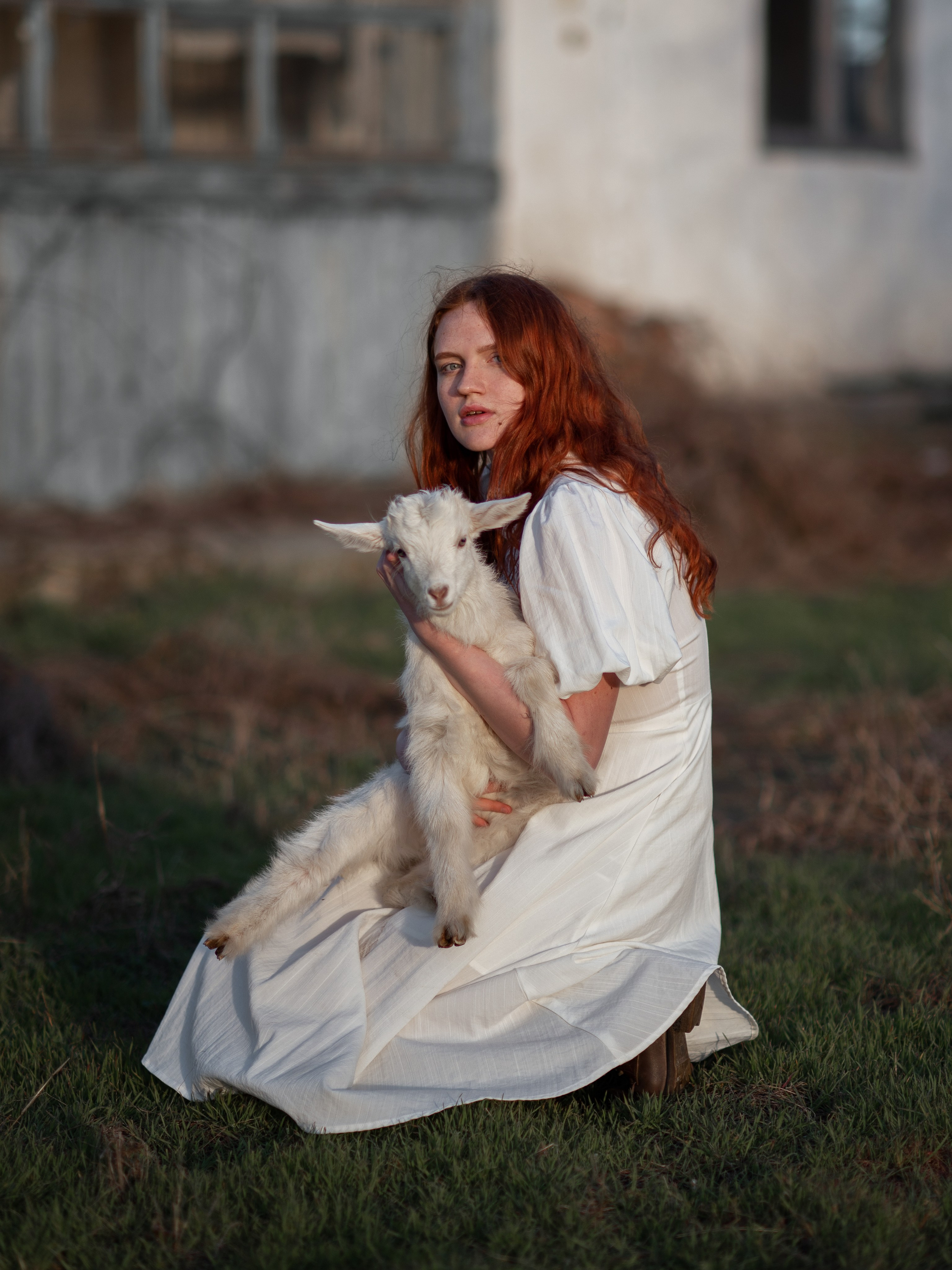 Рыжая девушка и белый козлик в деревне