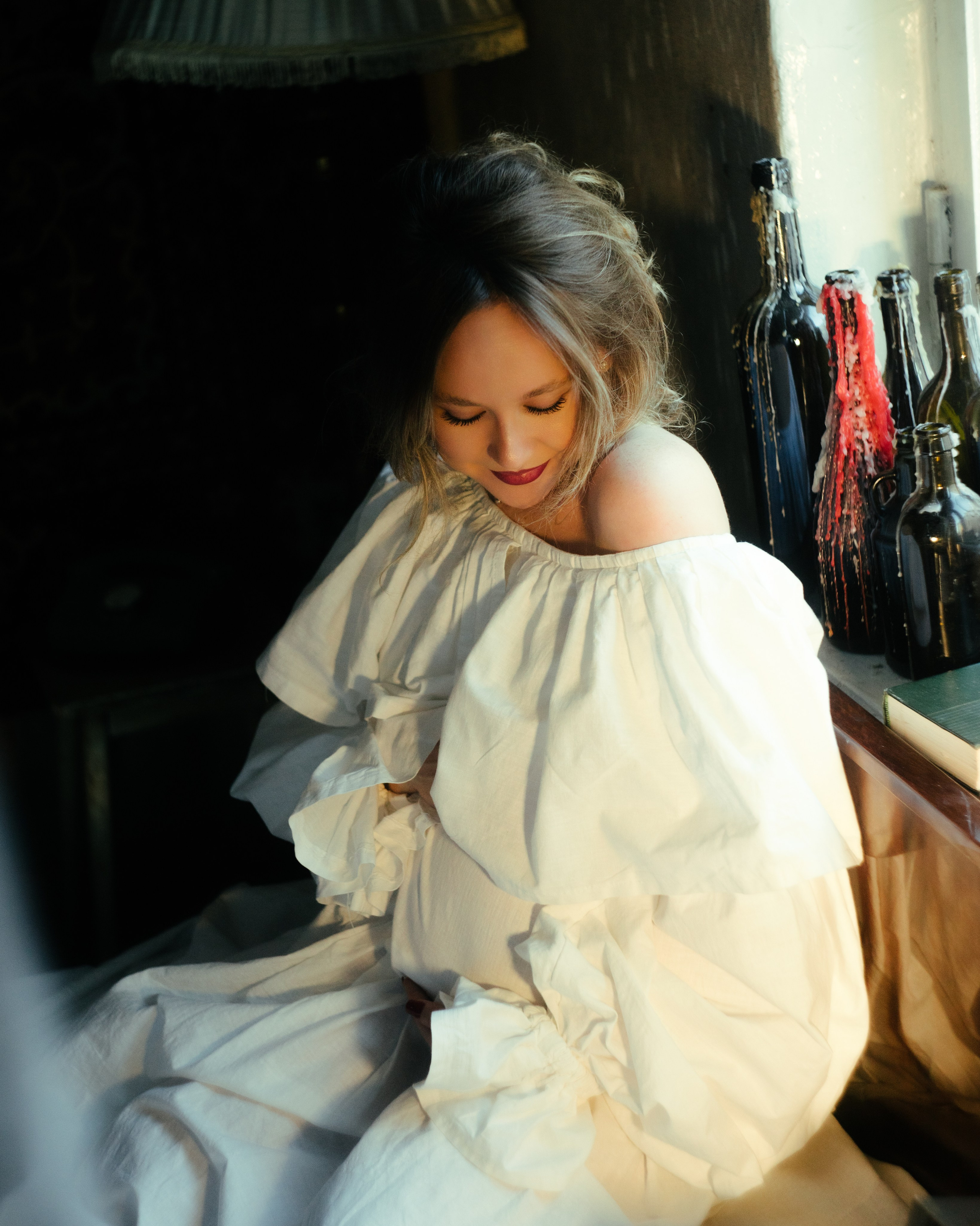 Портрет беременности у окна: беременная в винтажном белом платье, теплый свет — премиальная фотосессия в ретро-студии СПб.