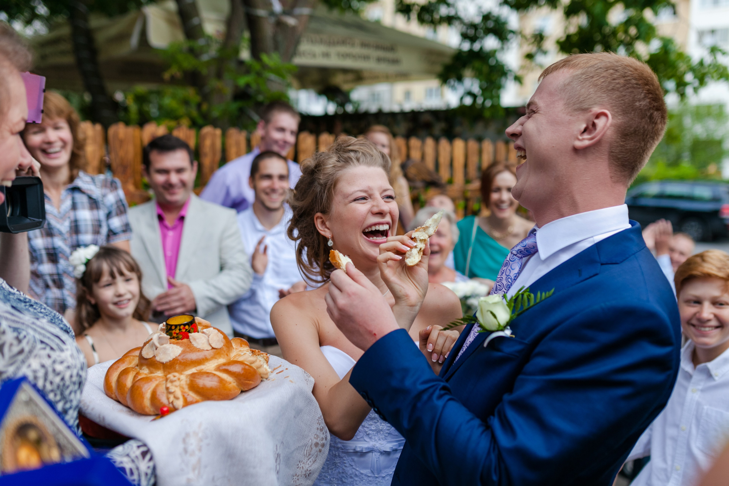 жених и невеста угощают друг друга свадебным караваем