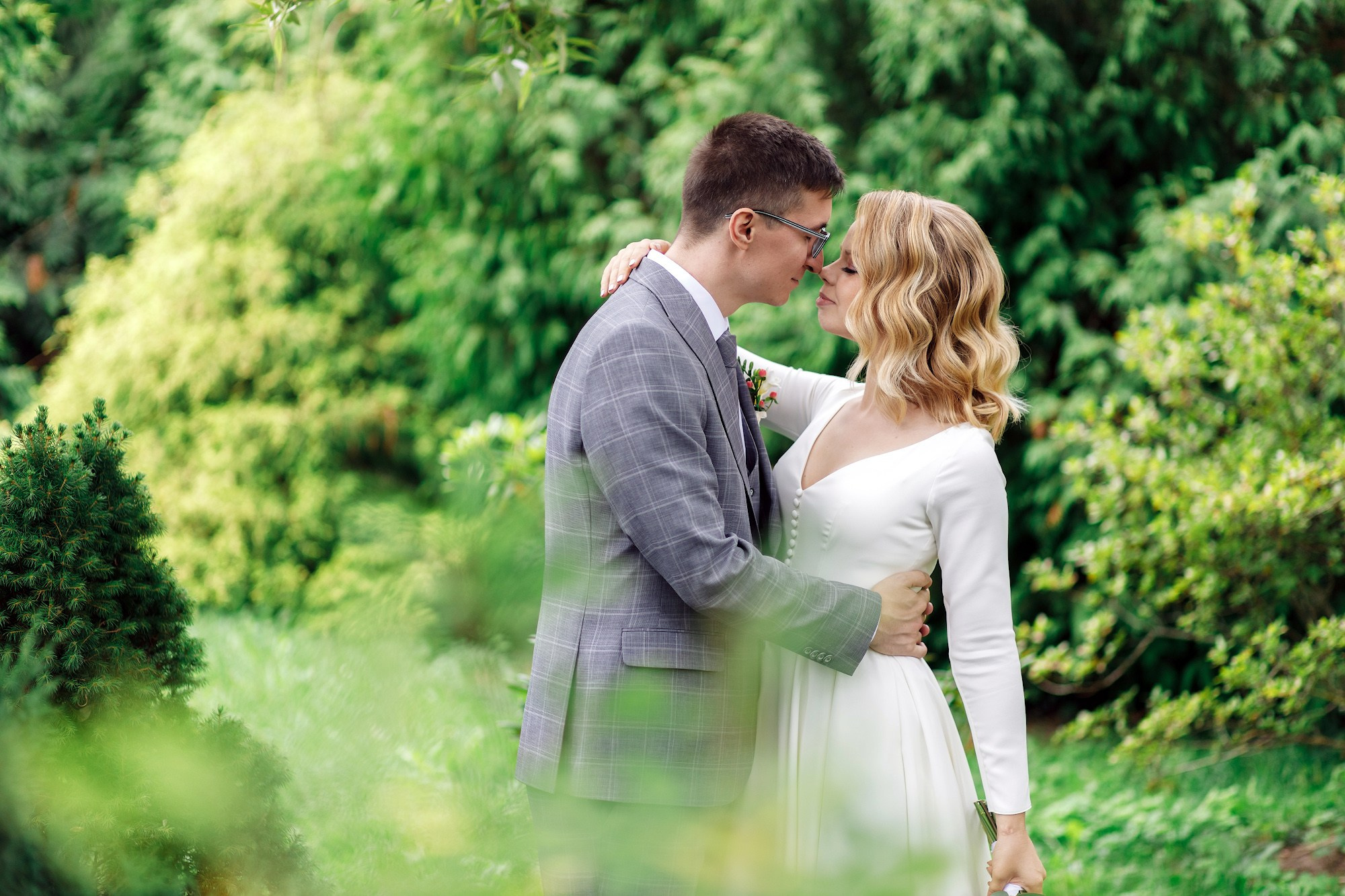 Жених целует невесту на свадебной прогулке