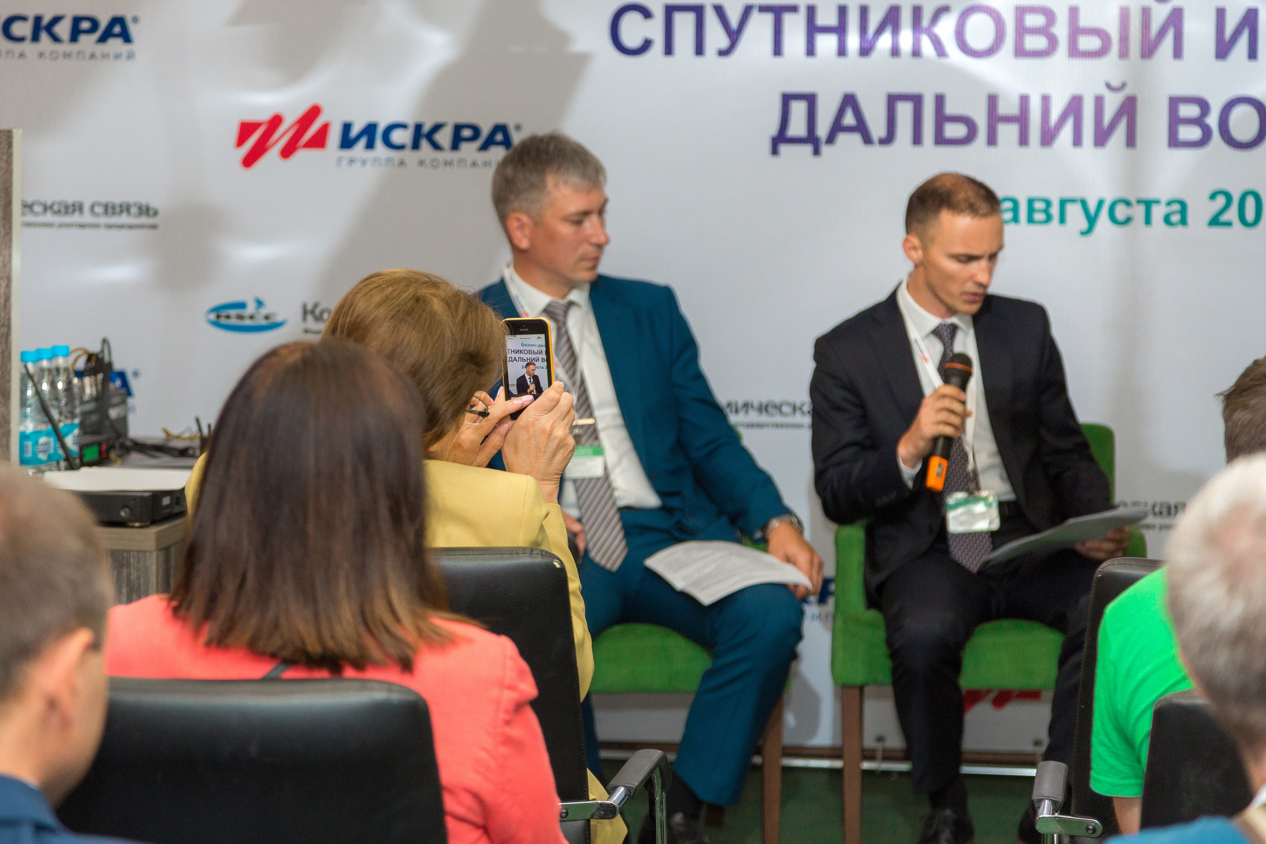 Спикер панельной дискуссии с микрофоном, фотограф деловых форумов Санкт-Петербург