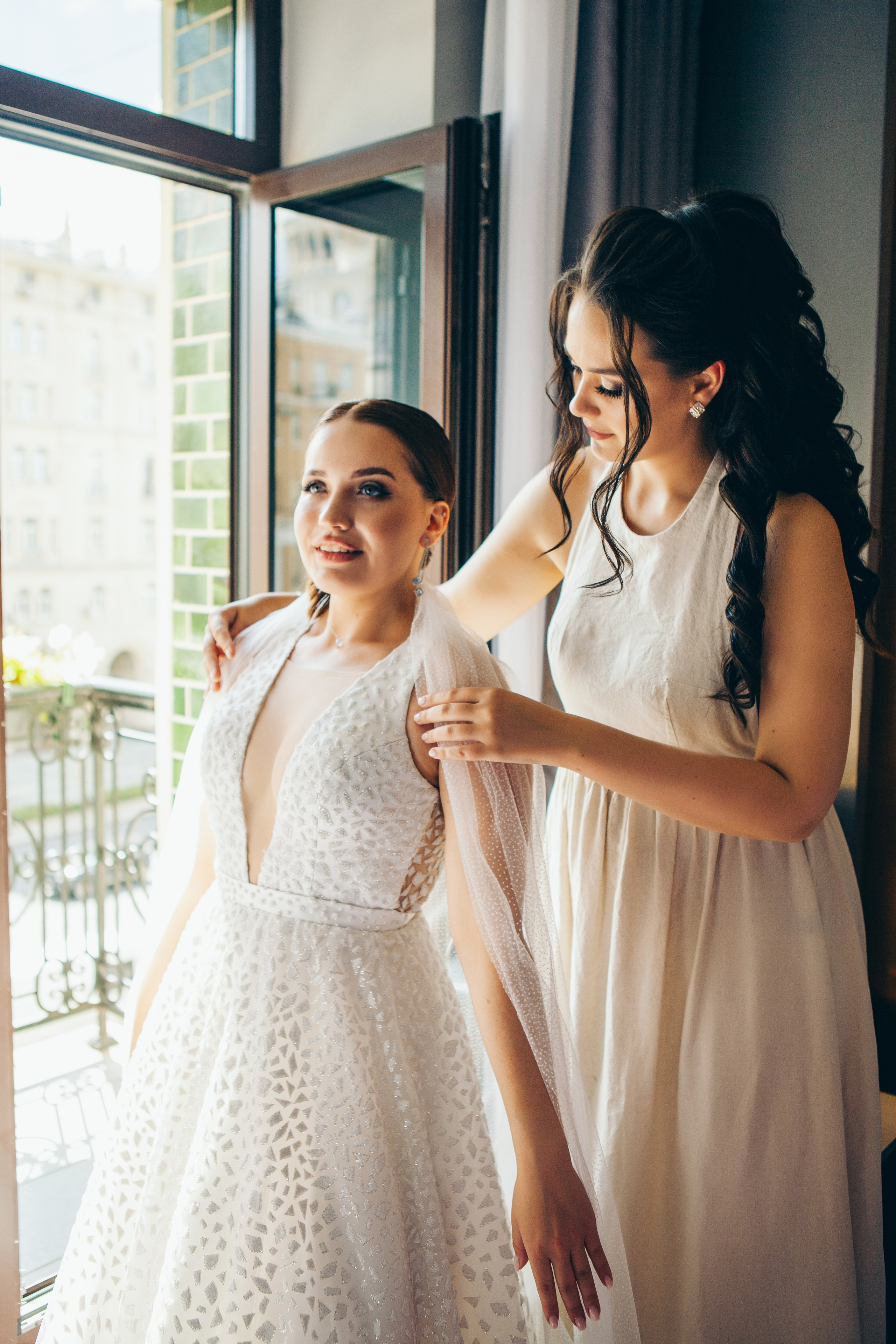 подруга поправляет фату будущей невесте