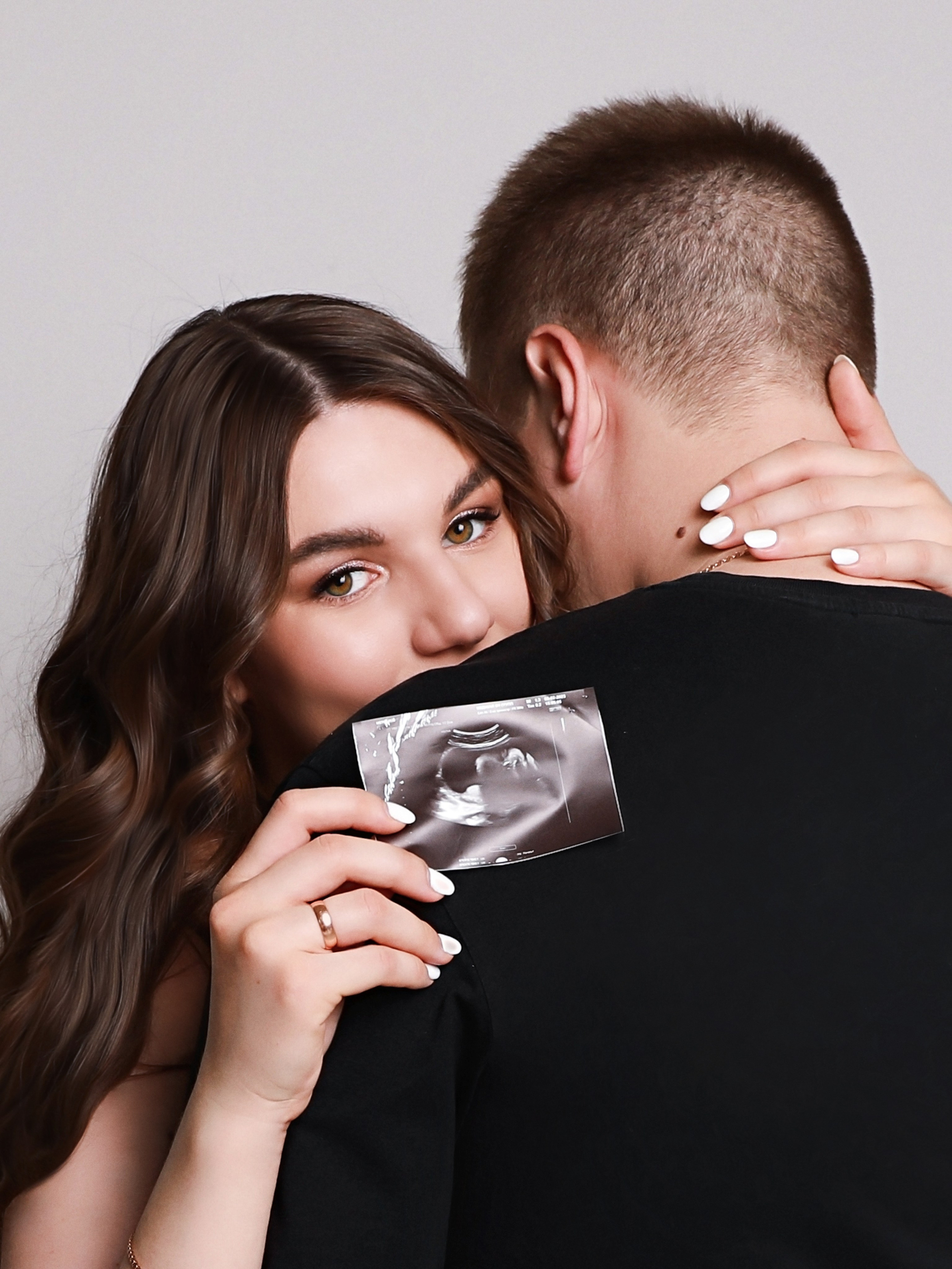 Фотография беременной девушки со снимком УЗИ