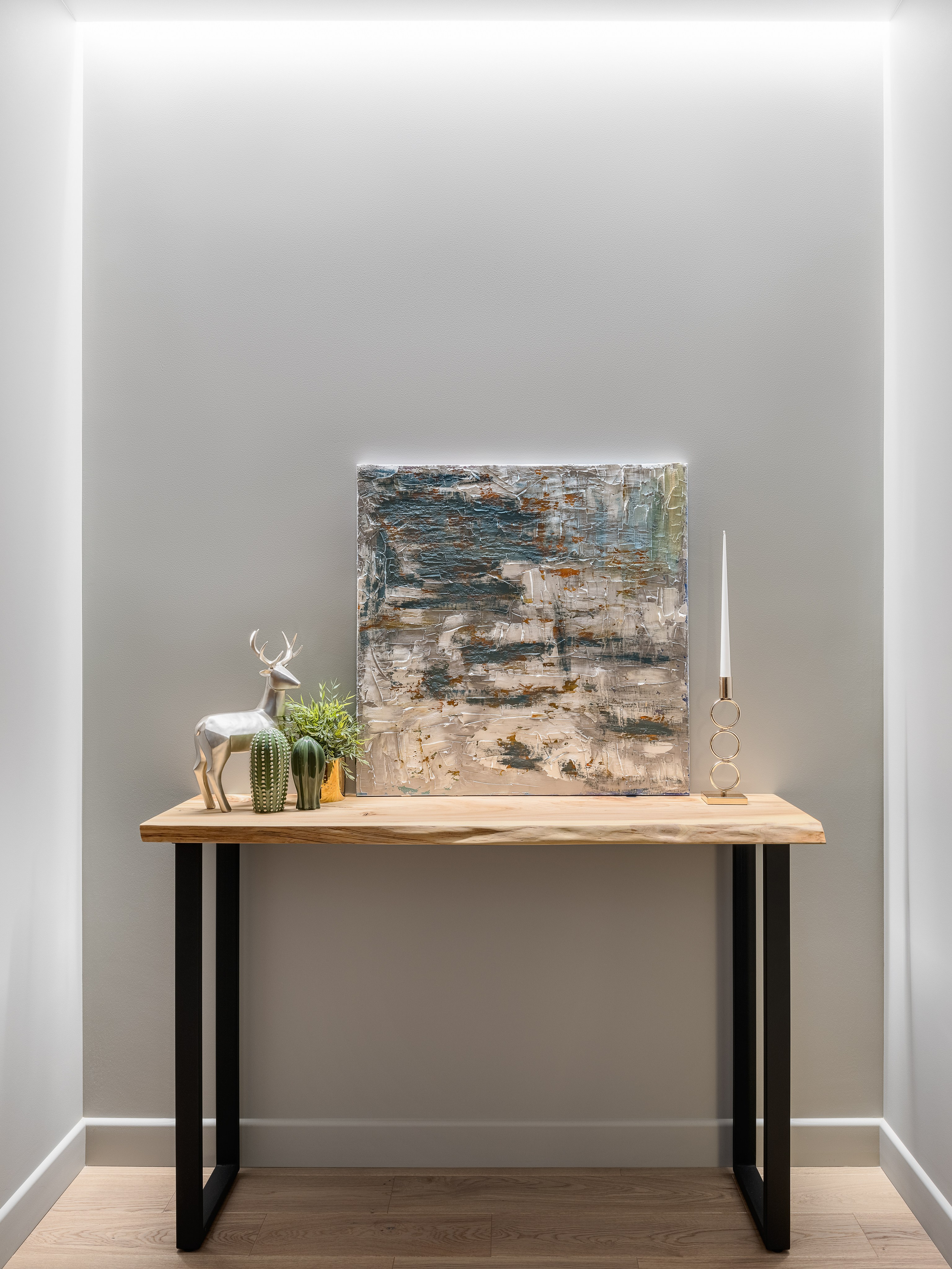 Узкая деревянная консоль с металлическими ножками в коридоре, украшенная картиной, статуэткой оленя и декоративными растениями, интерьер от Алёны Поповой и Анастасии Дмитриевой, фото Сергей Денисенко, современный минимализм.