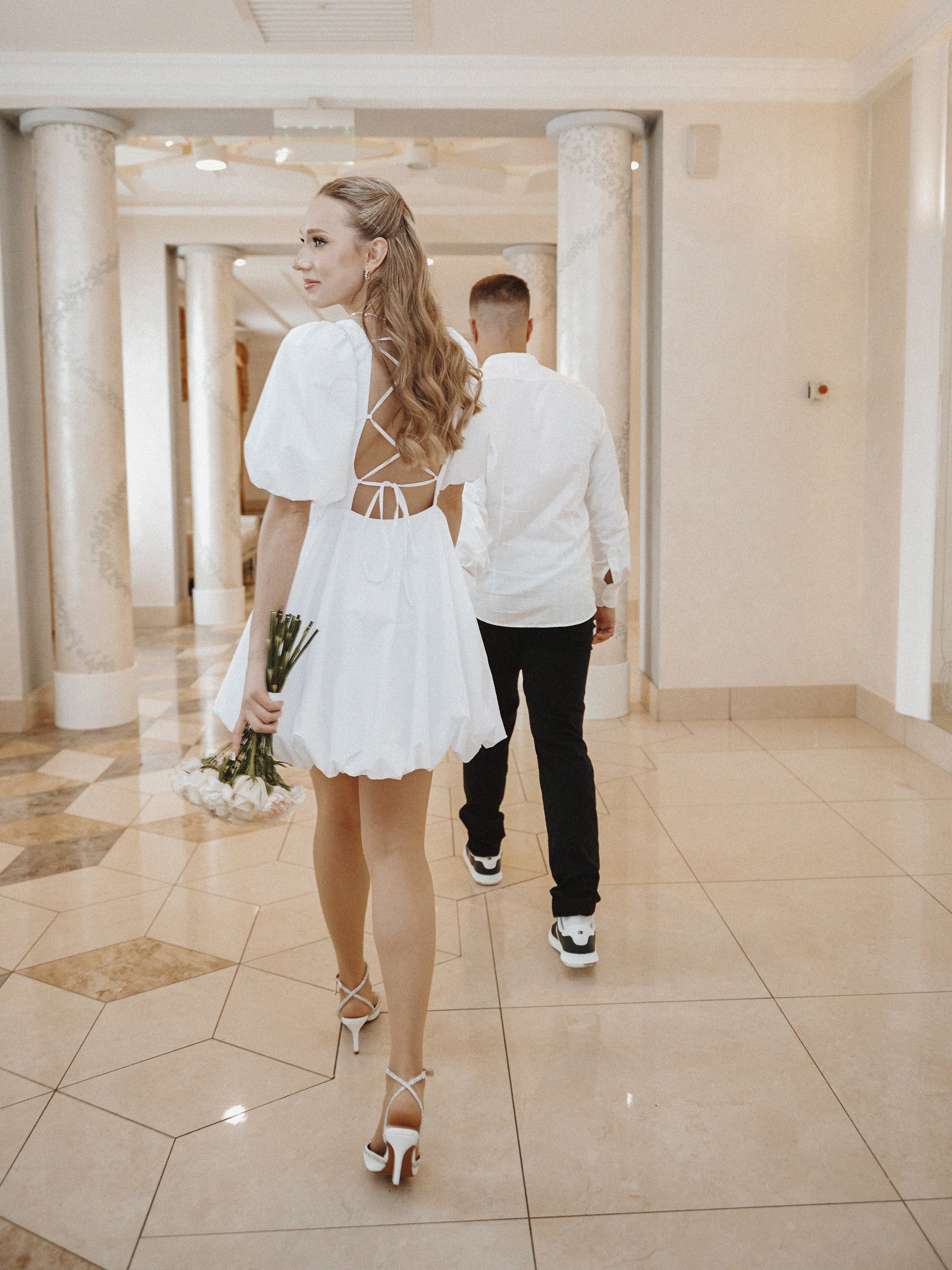 Невеста позирует у фасада ЖК Ричмонд — стильный городской свадебный портрет.