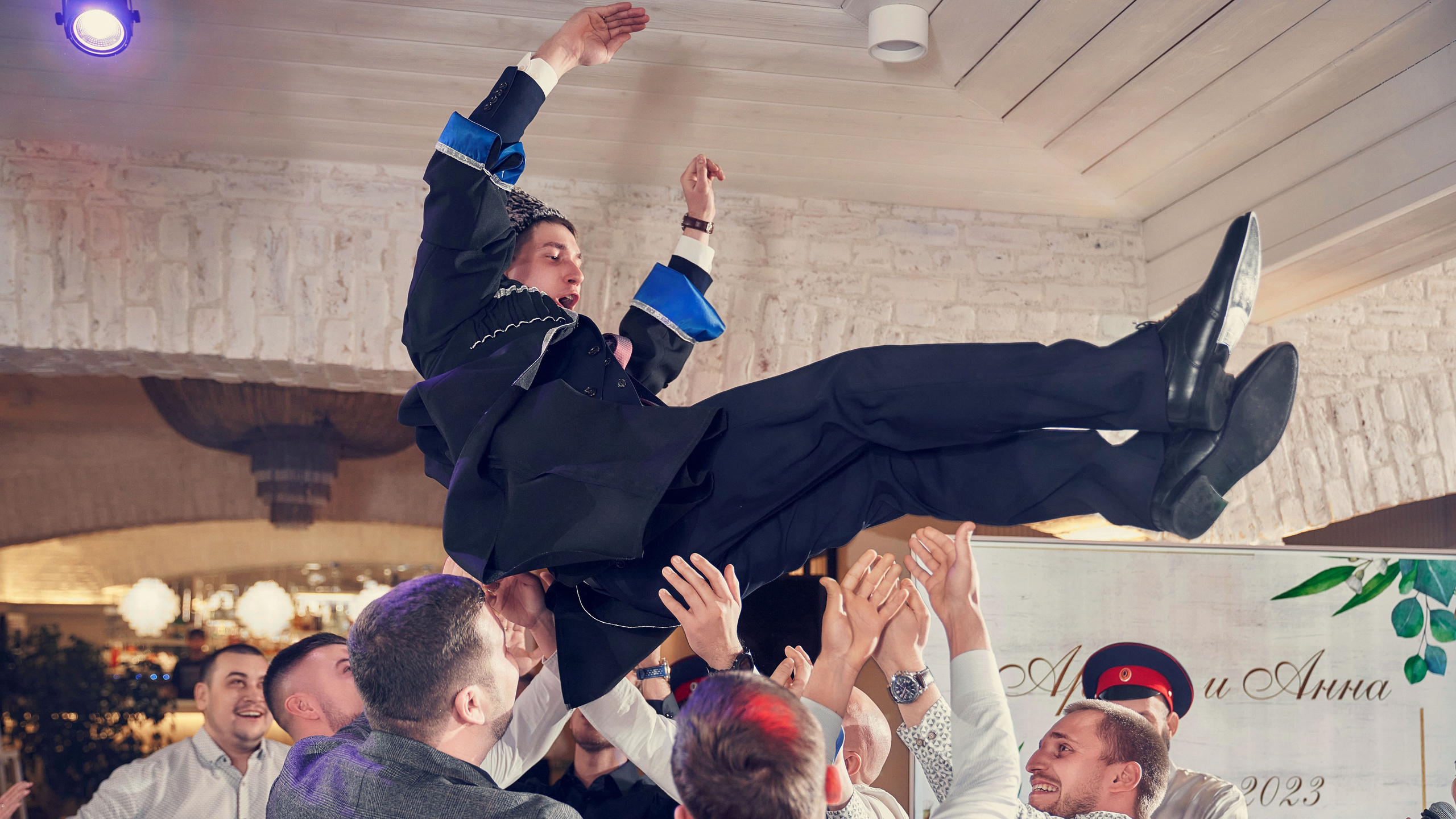 друзья подкидывают на руках жениха в папахе
