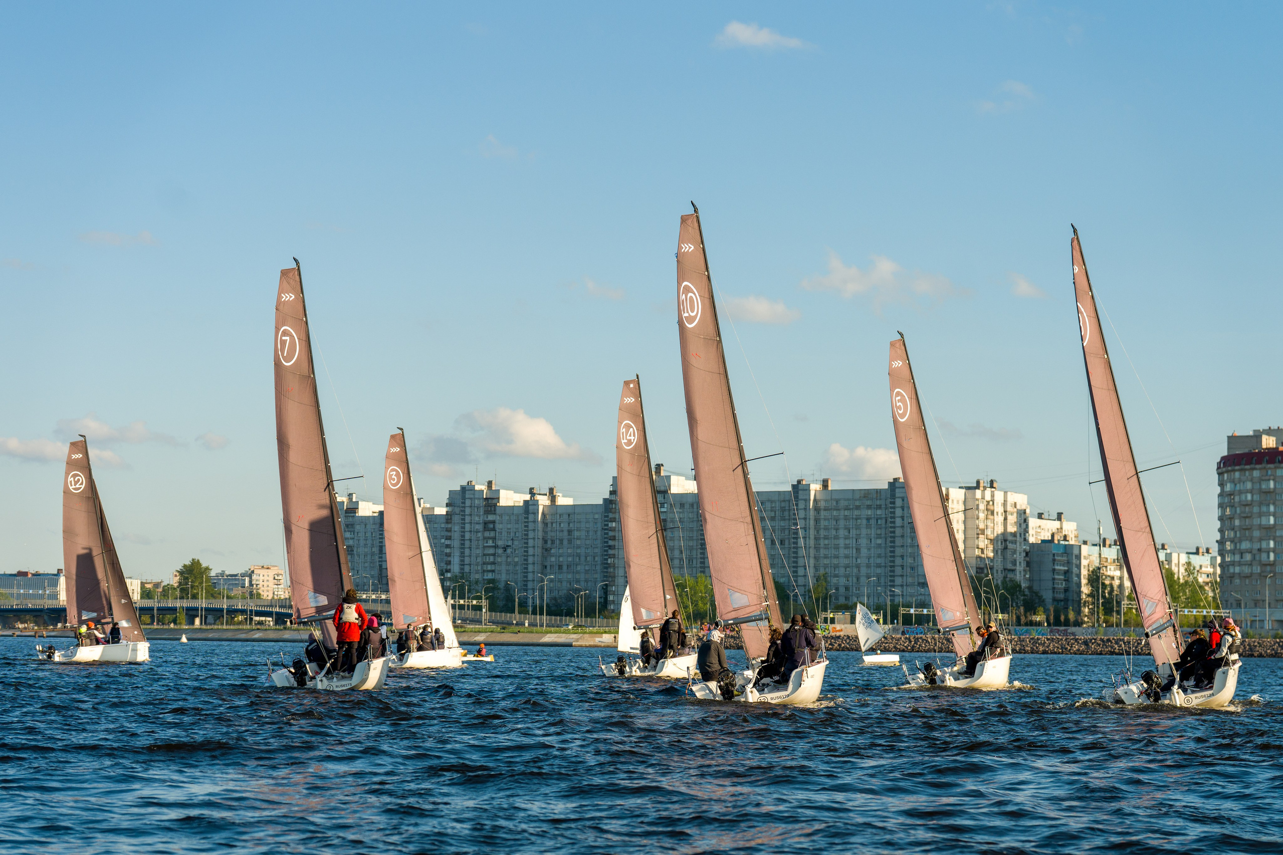 SV20 fleet pushes past the waterfront, crews trimming sheets hard