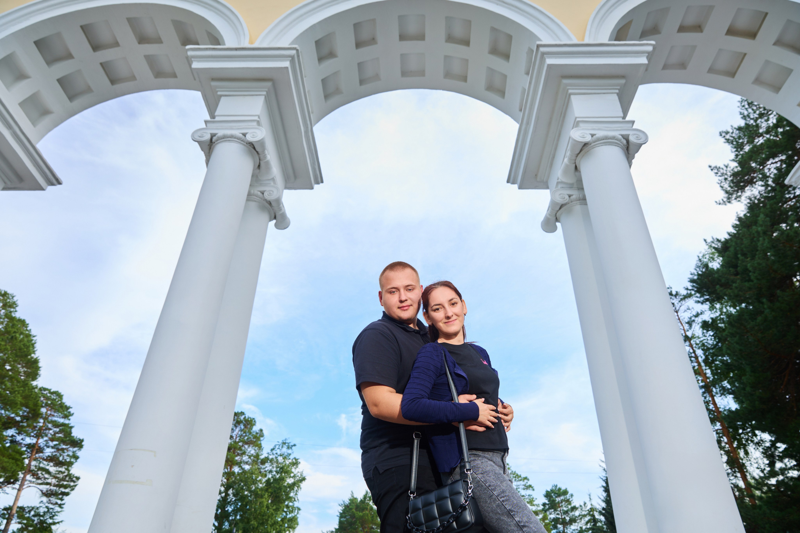 Пара обнимается между колонн арки стадиона "Труд"