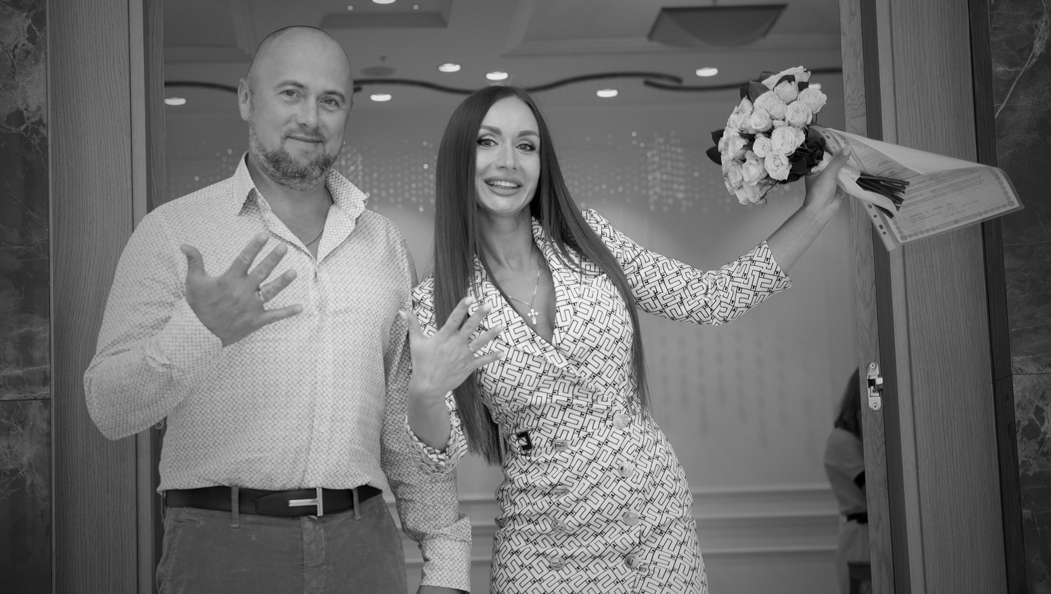 черно белое фото жениха с невестой которые только что надели обручальные кольца и показывают руки 