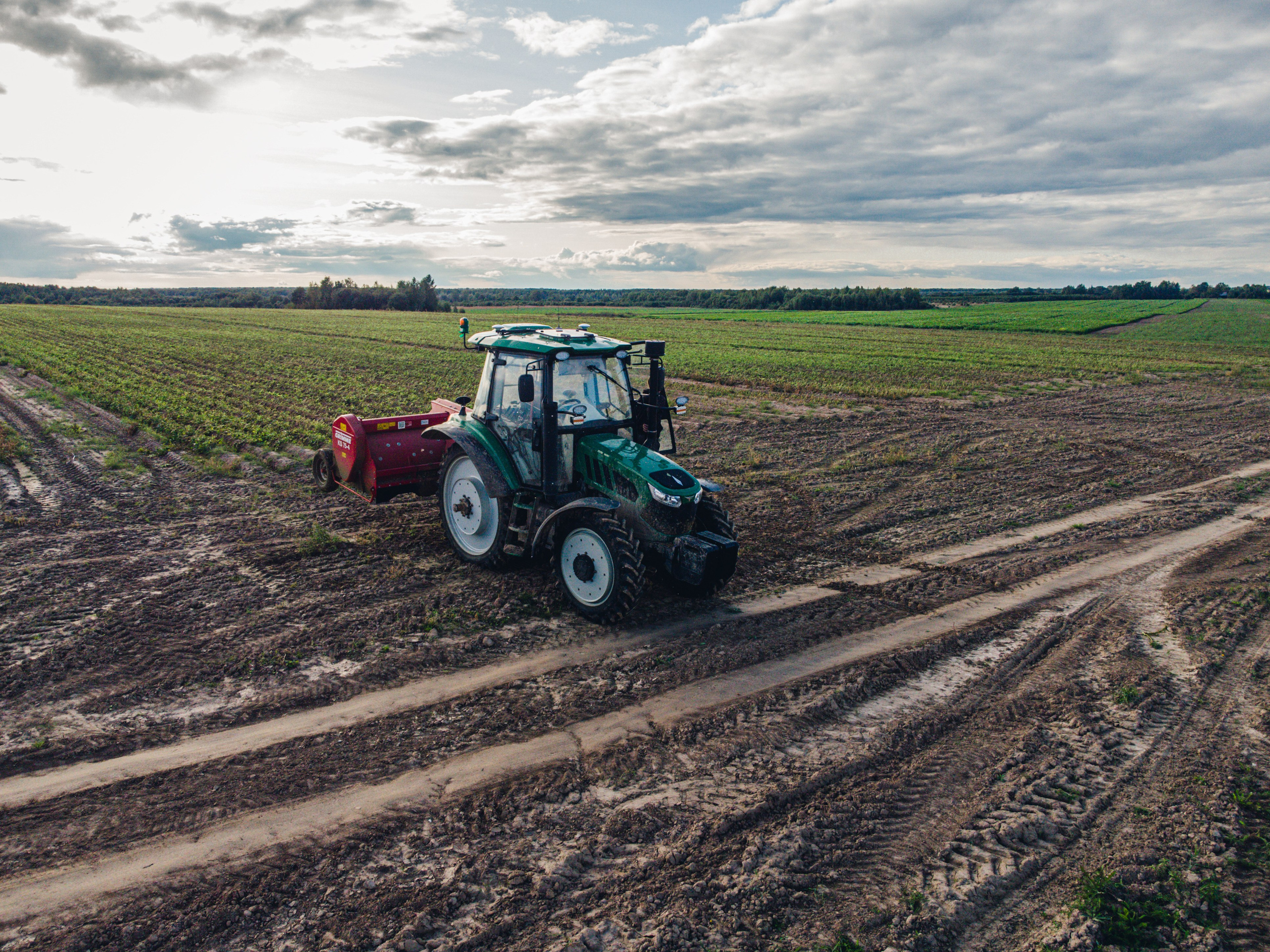 трактор в поле срезает ботву