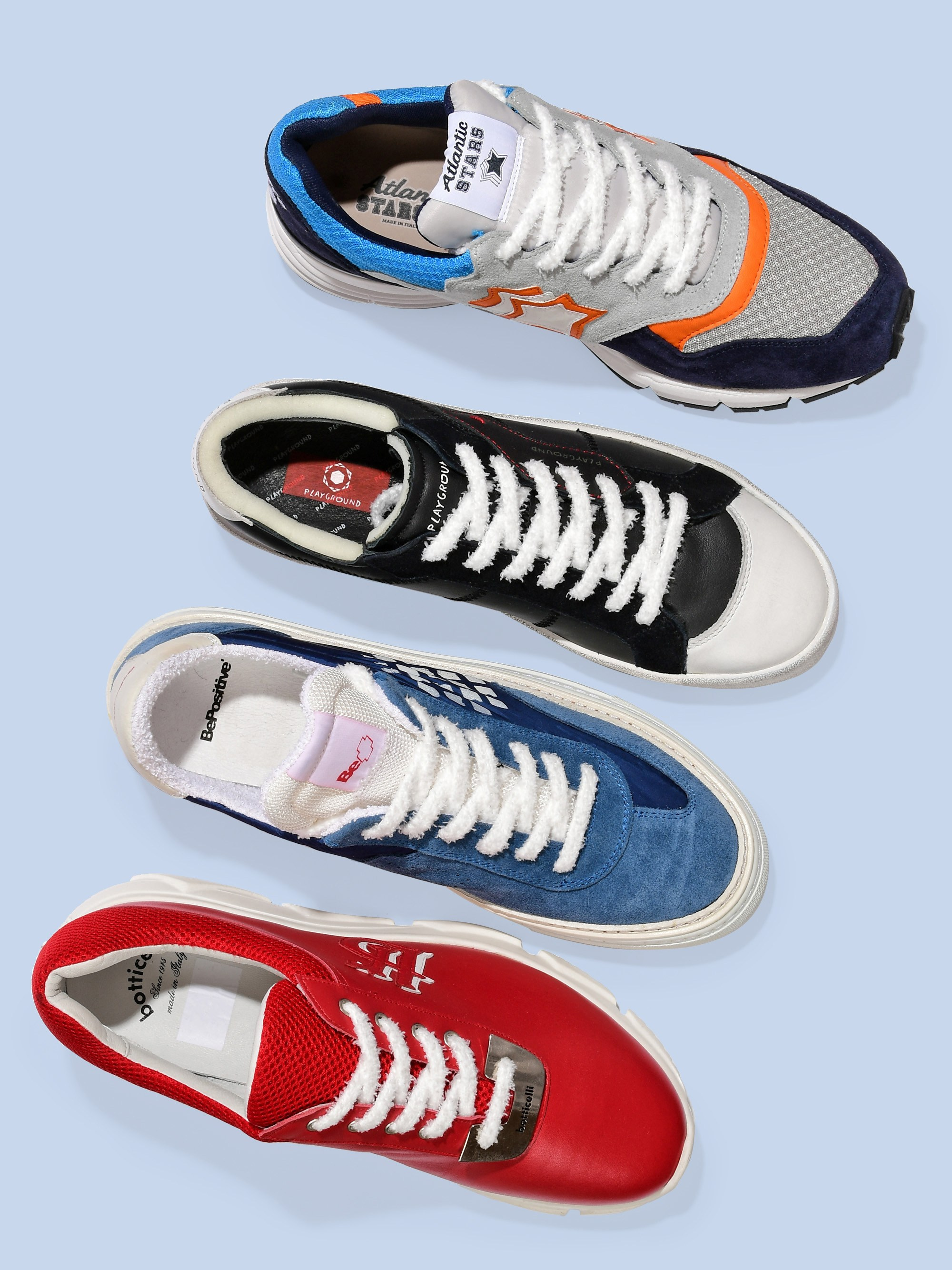 серый, черный, синий и красный кроссовки на голубом фоне