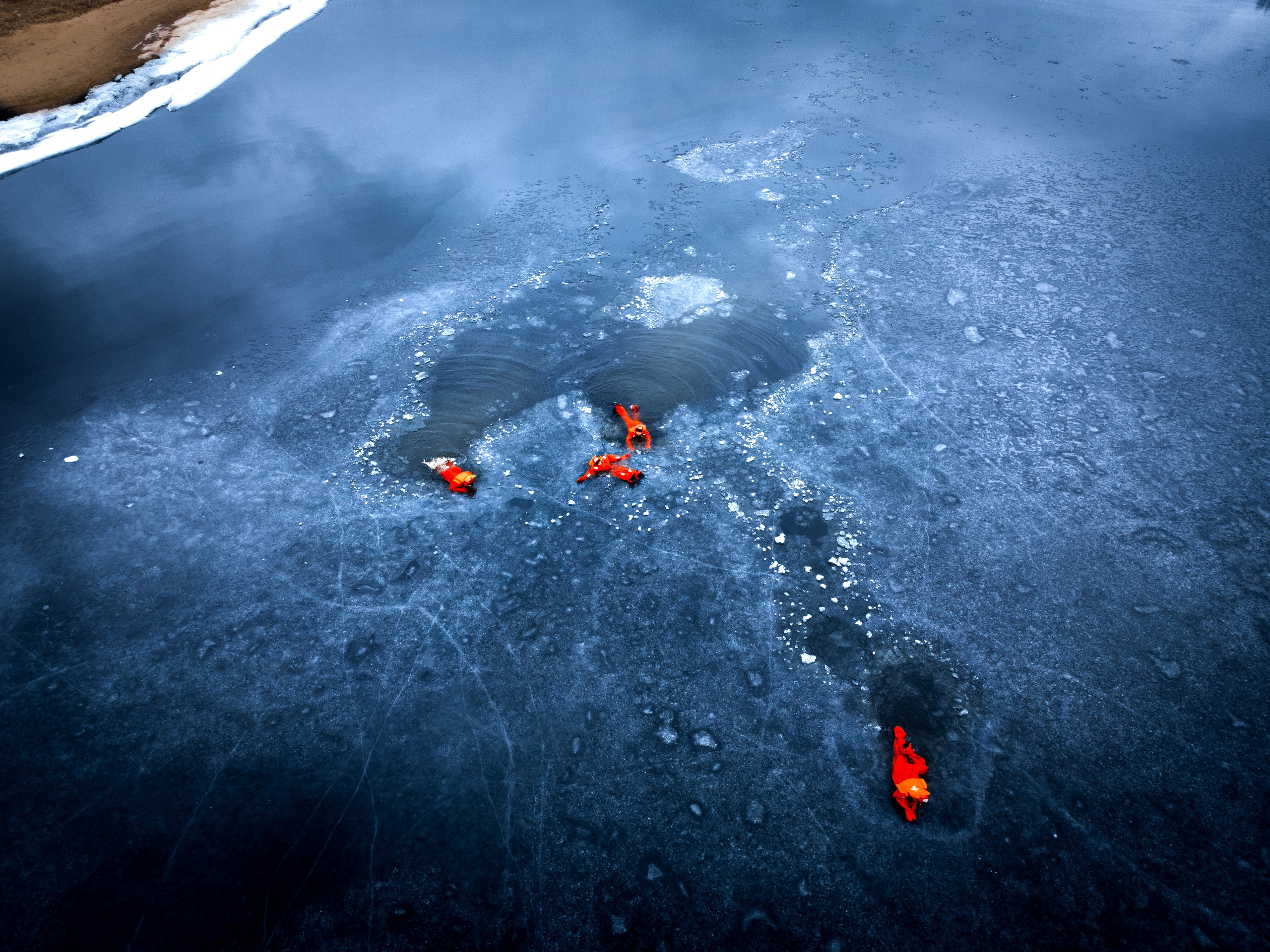 Люди купаются среди льдин, в спасательных оранжевых термо костюмах, айс флоатинг Ярославль