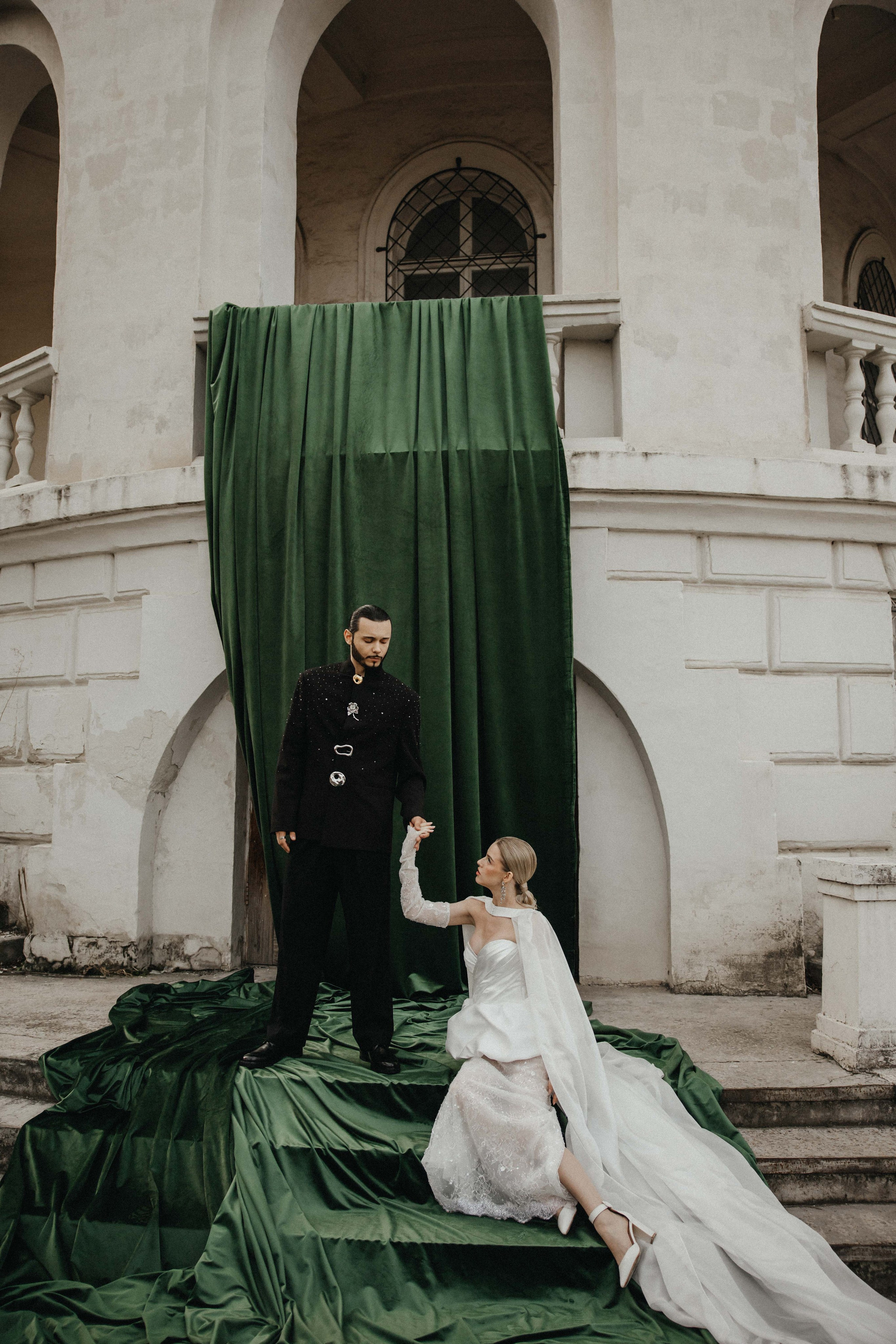Счастливая пара позирует на свадебной фотосессии на фоне зеленой ткани в театре ,фэшн съемка ,топ 100 — свадебный фотограф Алена Межевова
