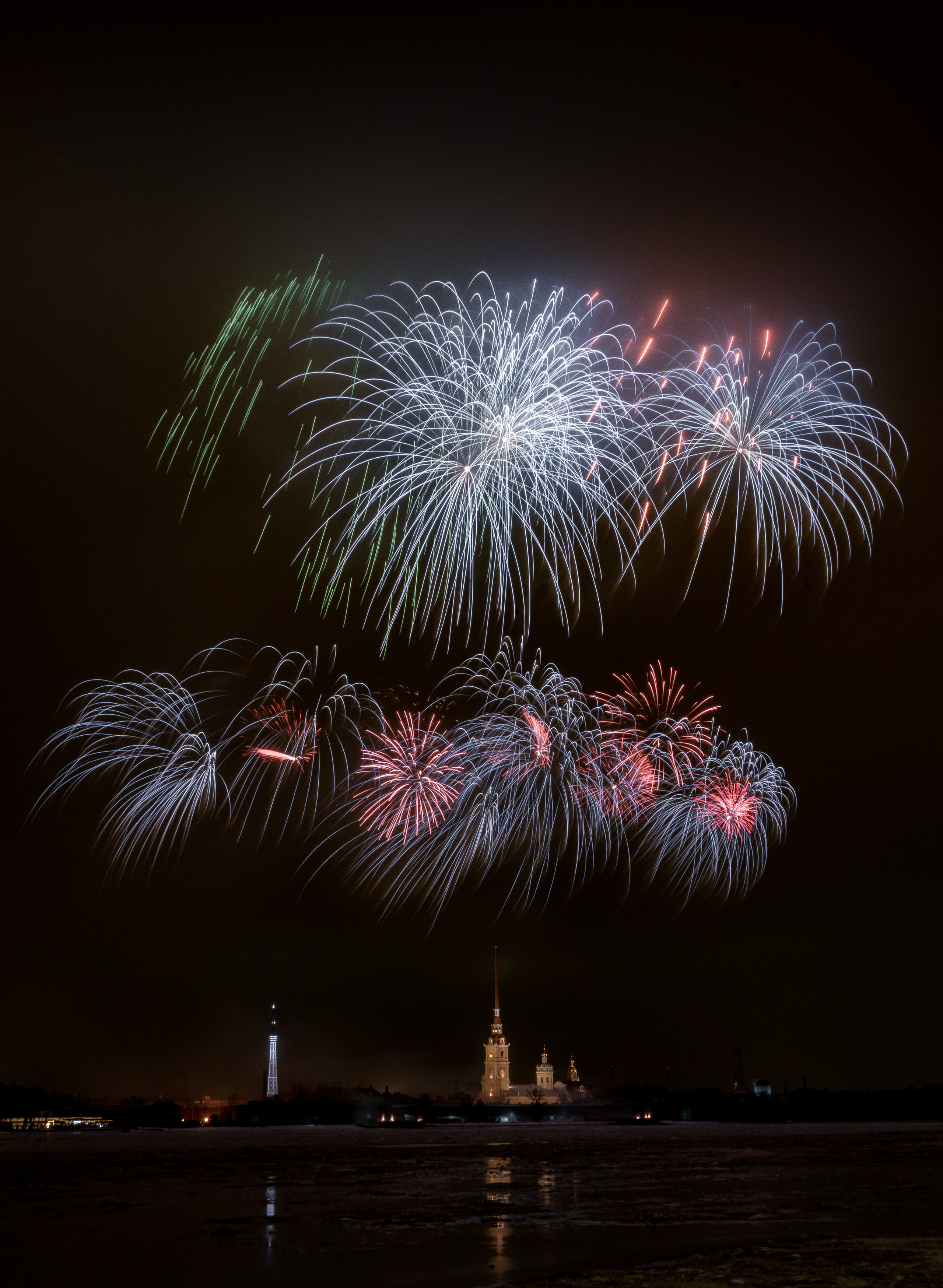 Салют над Петропавловской крепостью в Санкт-Петербурге, яркий фейерверк на фоне ночного неба и шпилей, праздничная фотография города.