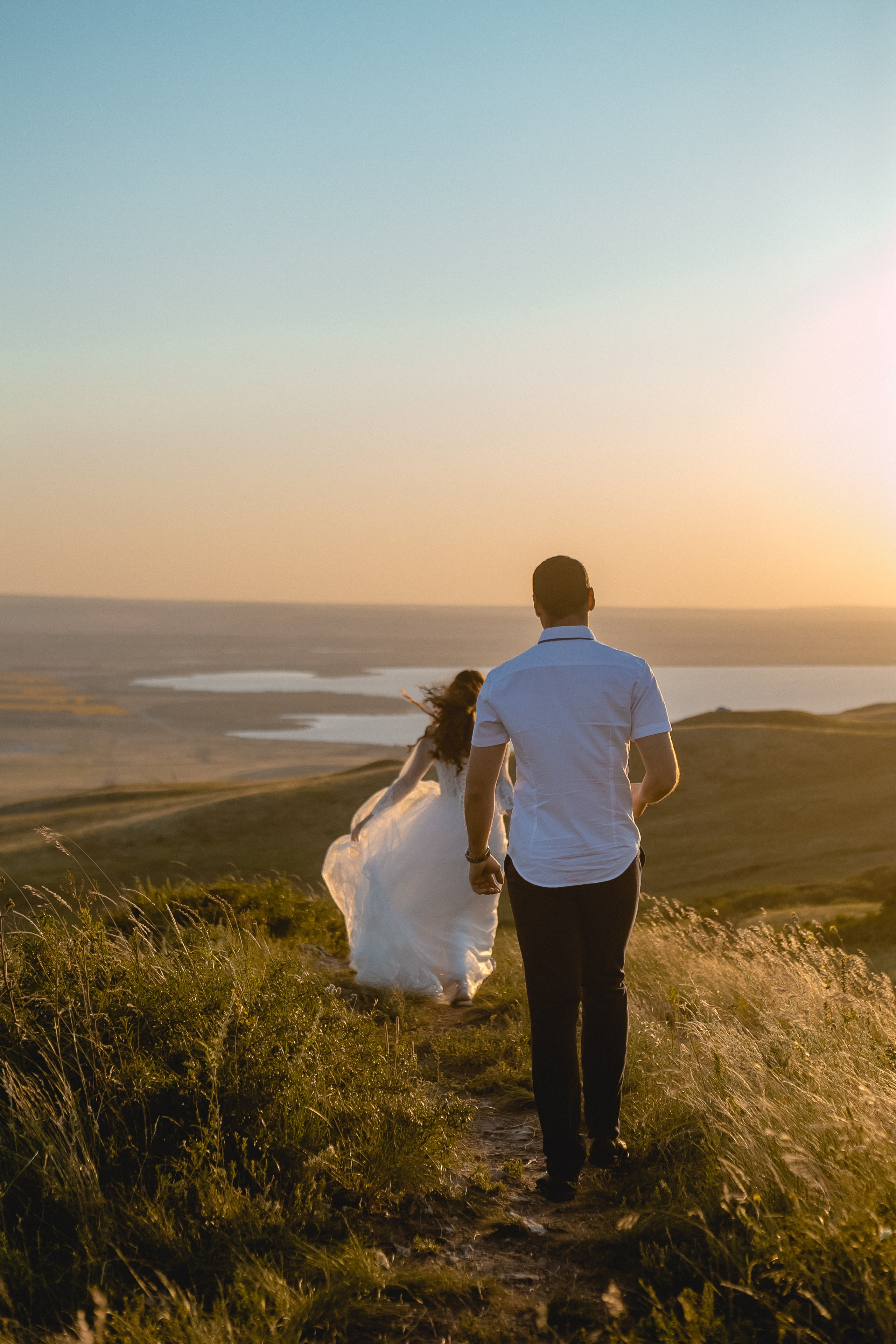 Счастливая пара на фоне заката - Счастливая молодожен на фоне заката, сделанное профессиональным свадебным фотографом