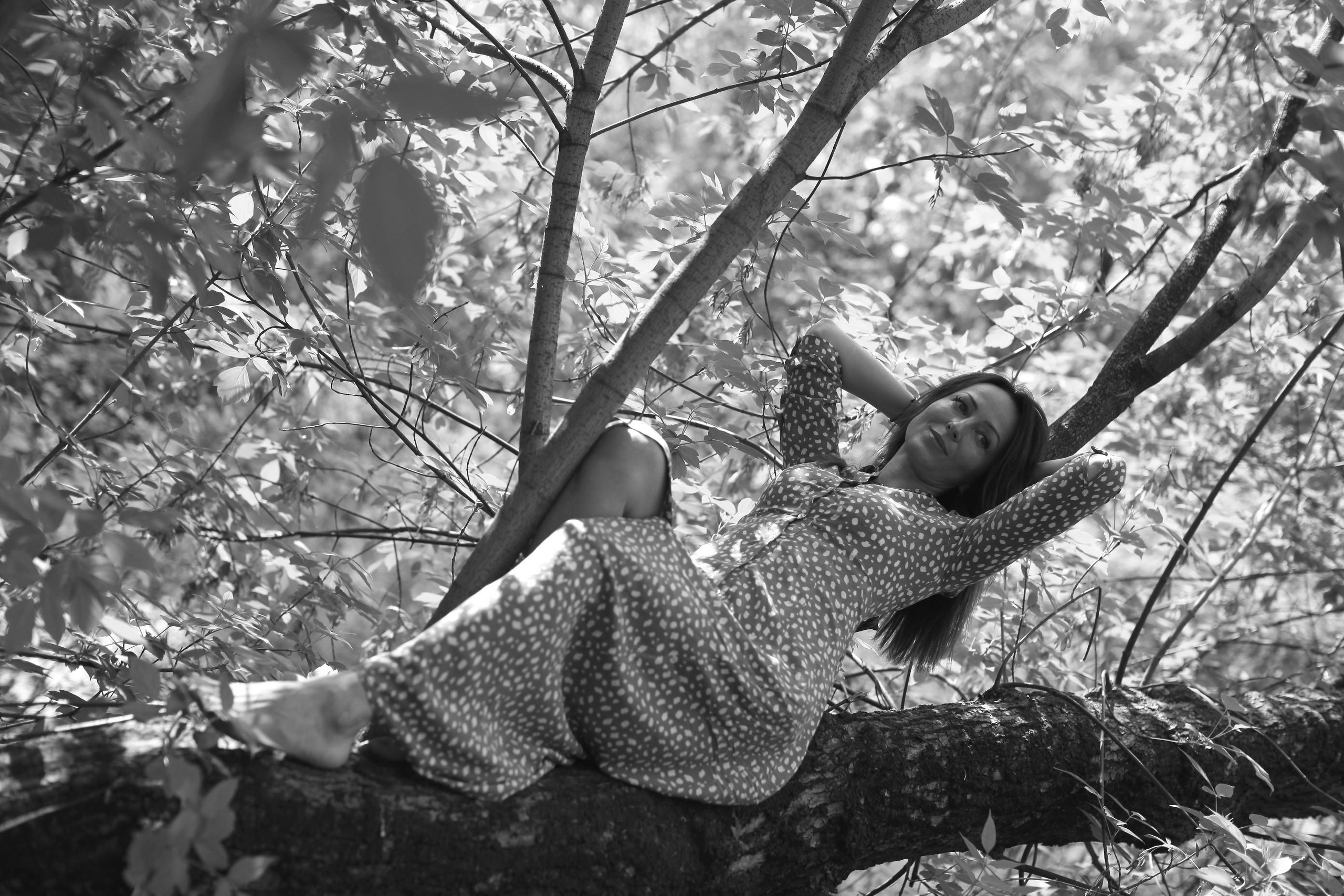 черно белая фотография девушки на дереве
