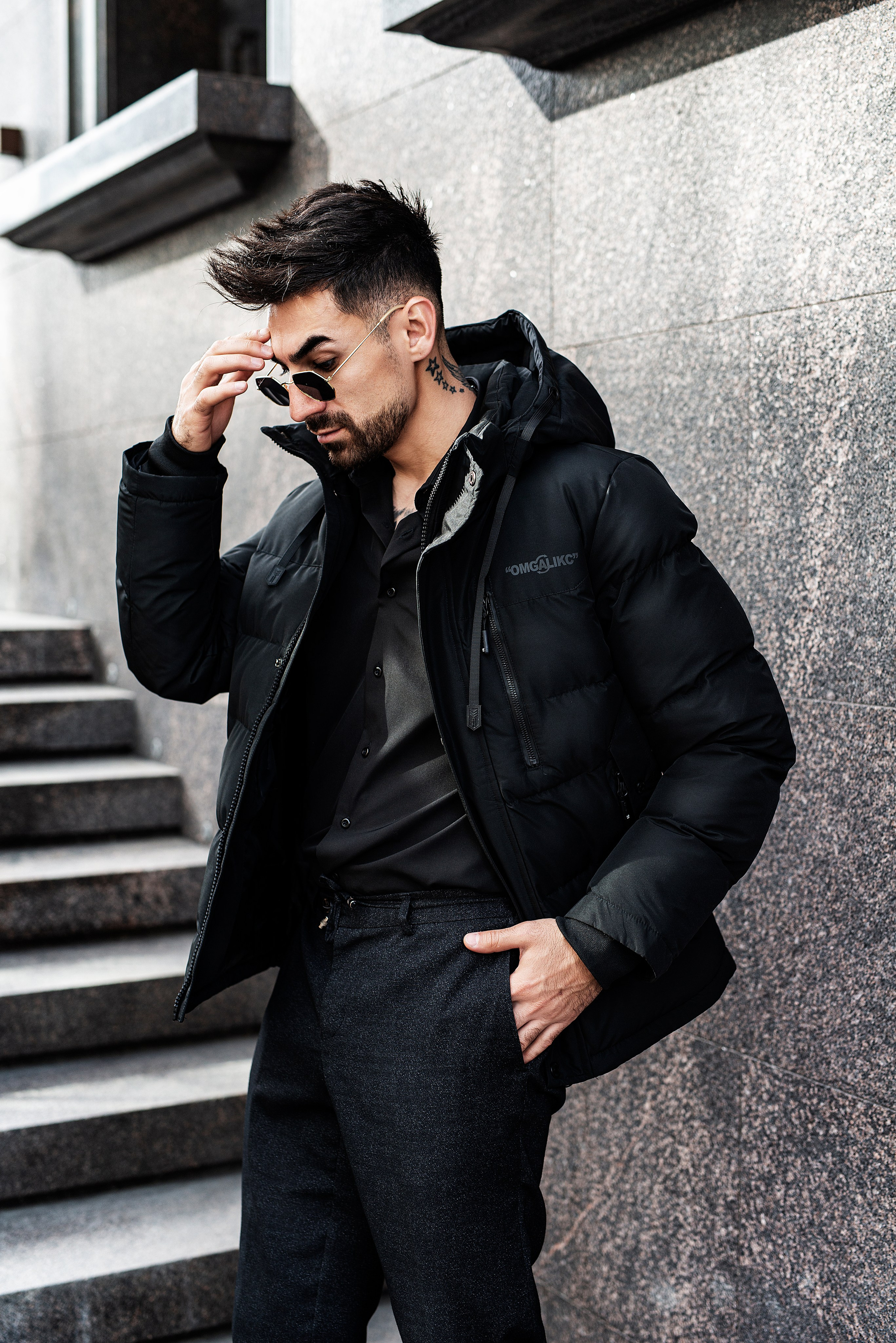 Красивый мужчина стоит в задумчивой позе во время фотосессии