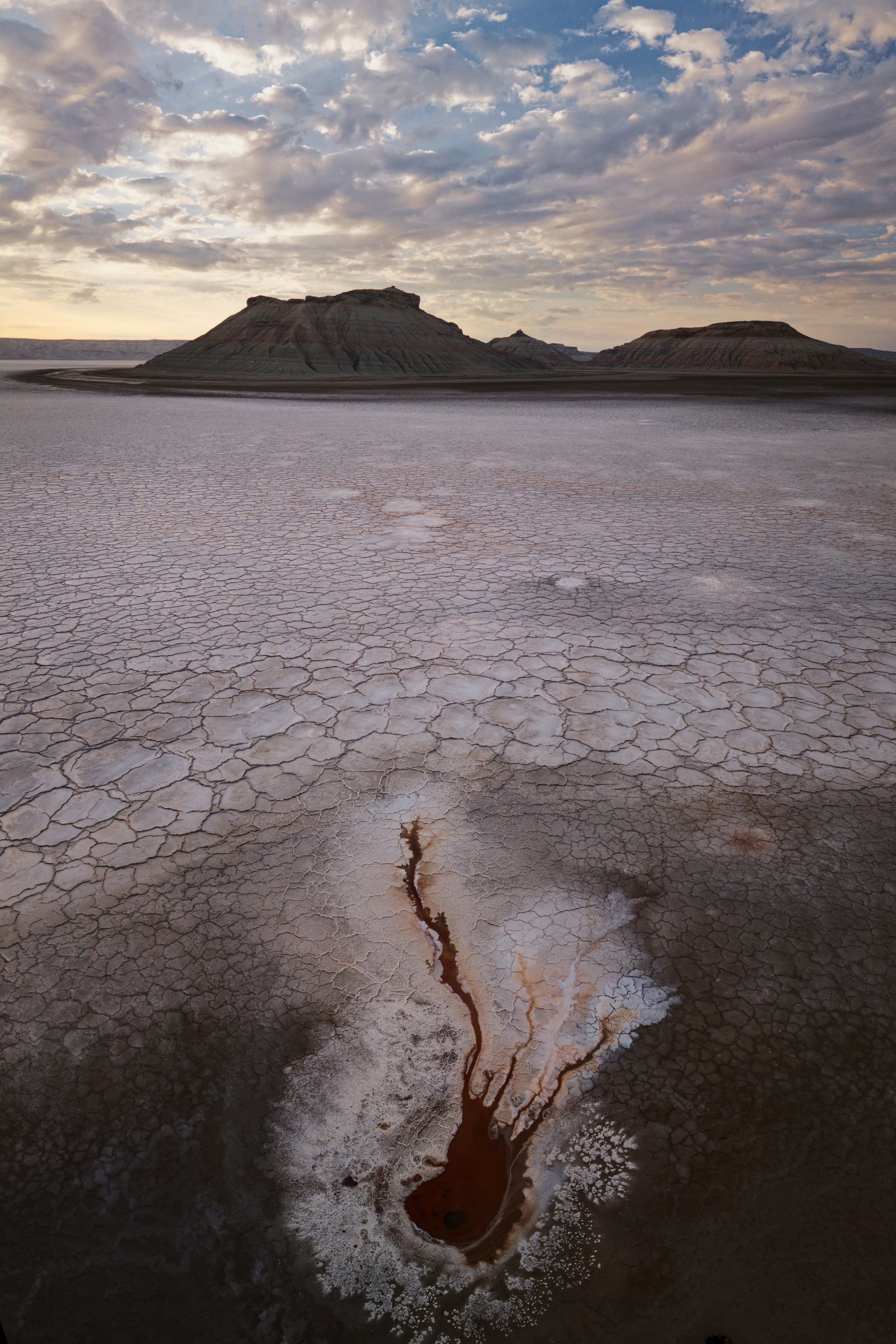Рассвет на Карынжарыке, источник на переднем плане, солончак и горы Три брата на фоне рассвета на заднем