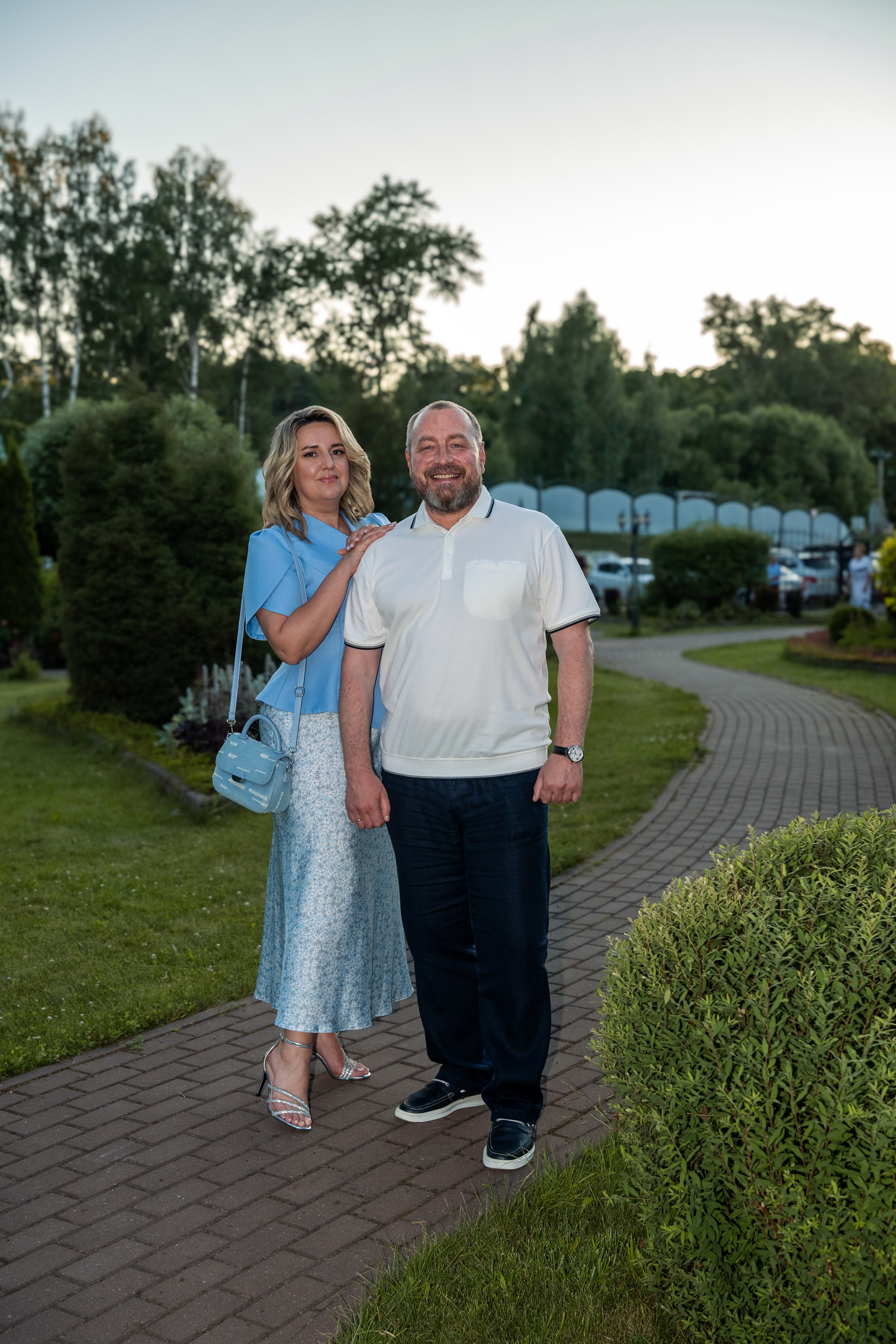 Родители выпускницы-обладательницы золотой медали позируют фотографу в парковой зоне ресторана Городок в Кохме