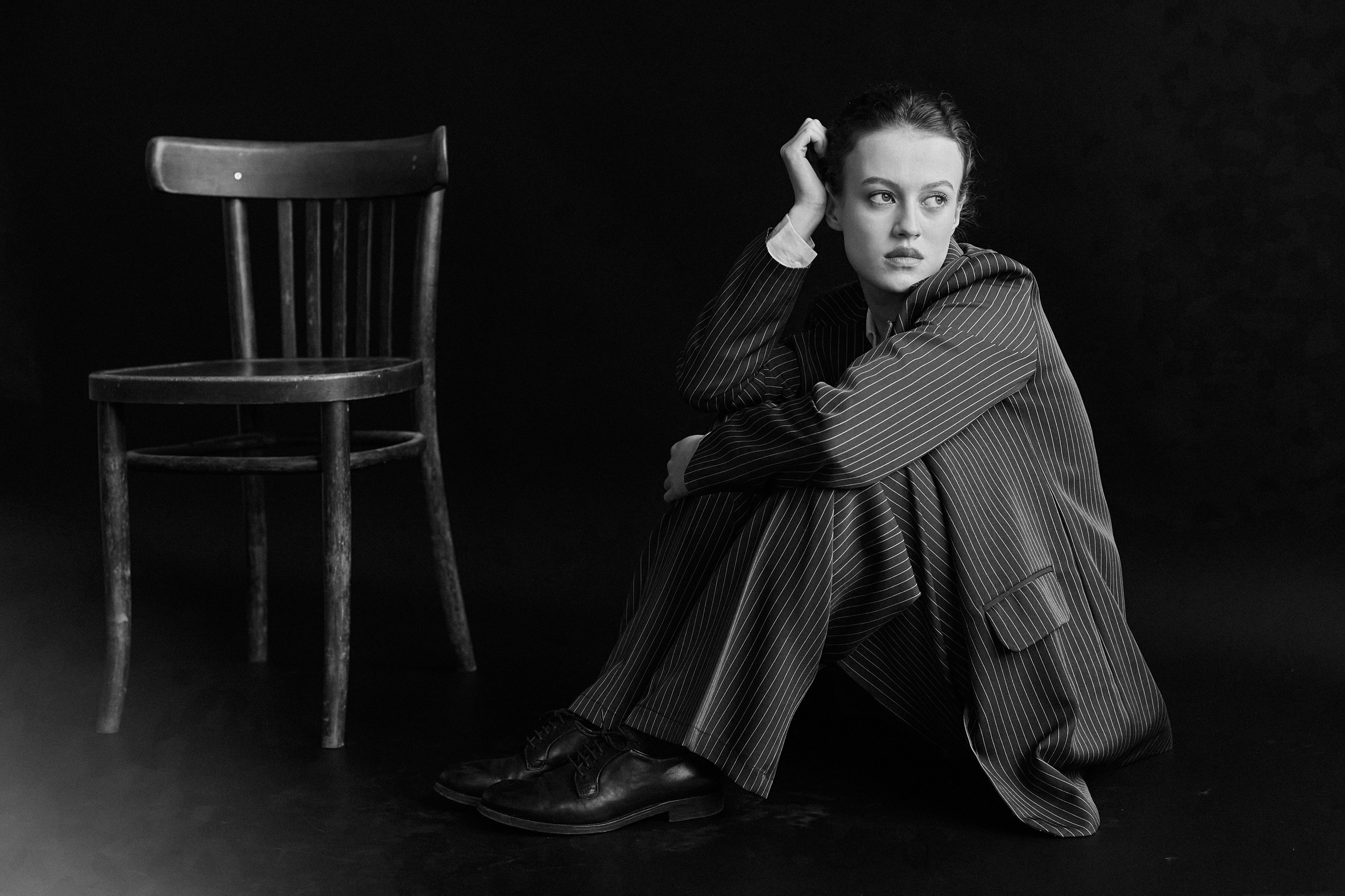 Фотограф в Москве. Студия. Студийный портрет. Девушка в пиджаке. Девушка на стуле на черном фоне. Красивая девушка в мужском костюме. Женский портрет. Черно-белое фото.