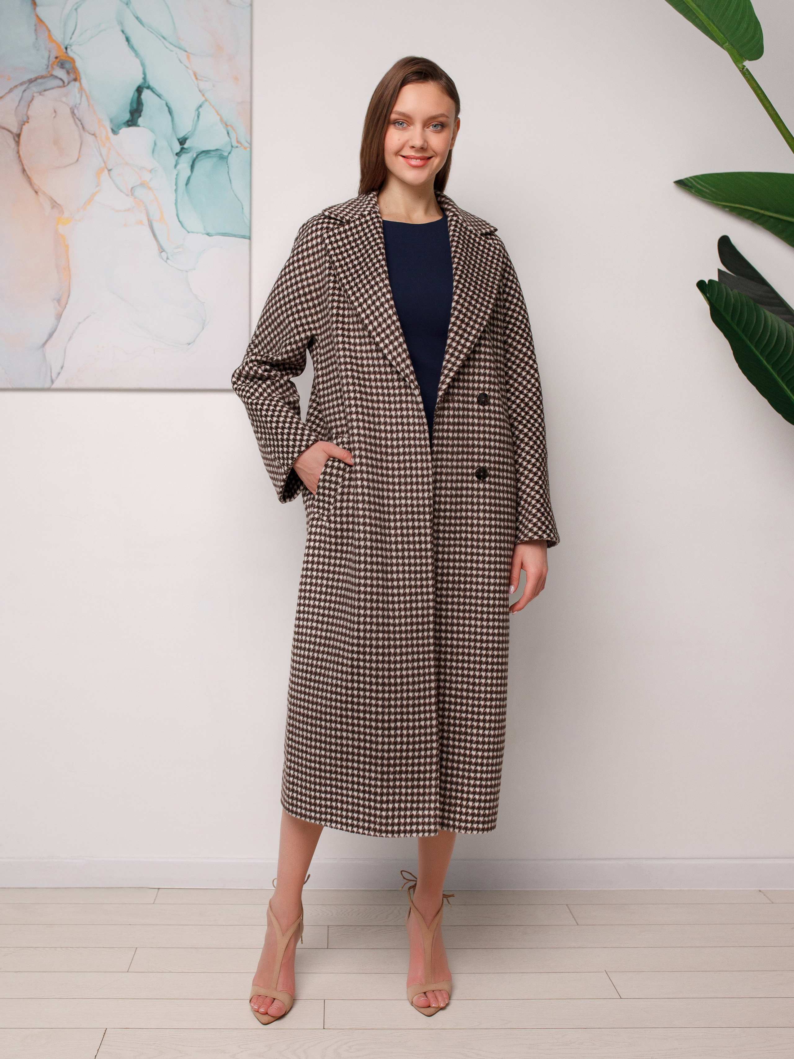 Высокая модель позирует в интерьере фотостудии для съёмки каталога