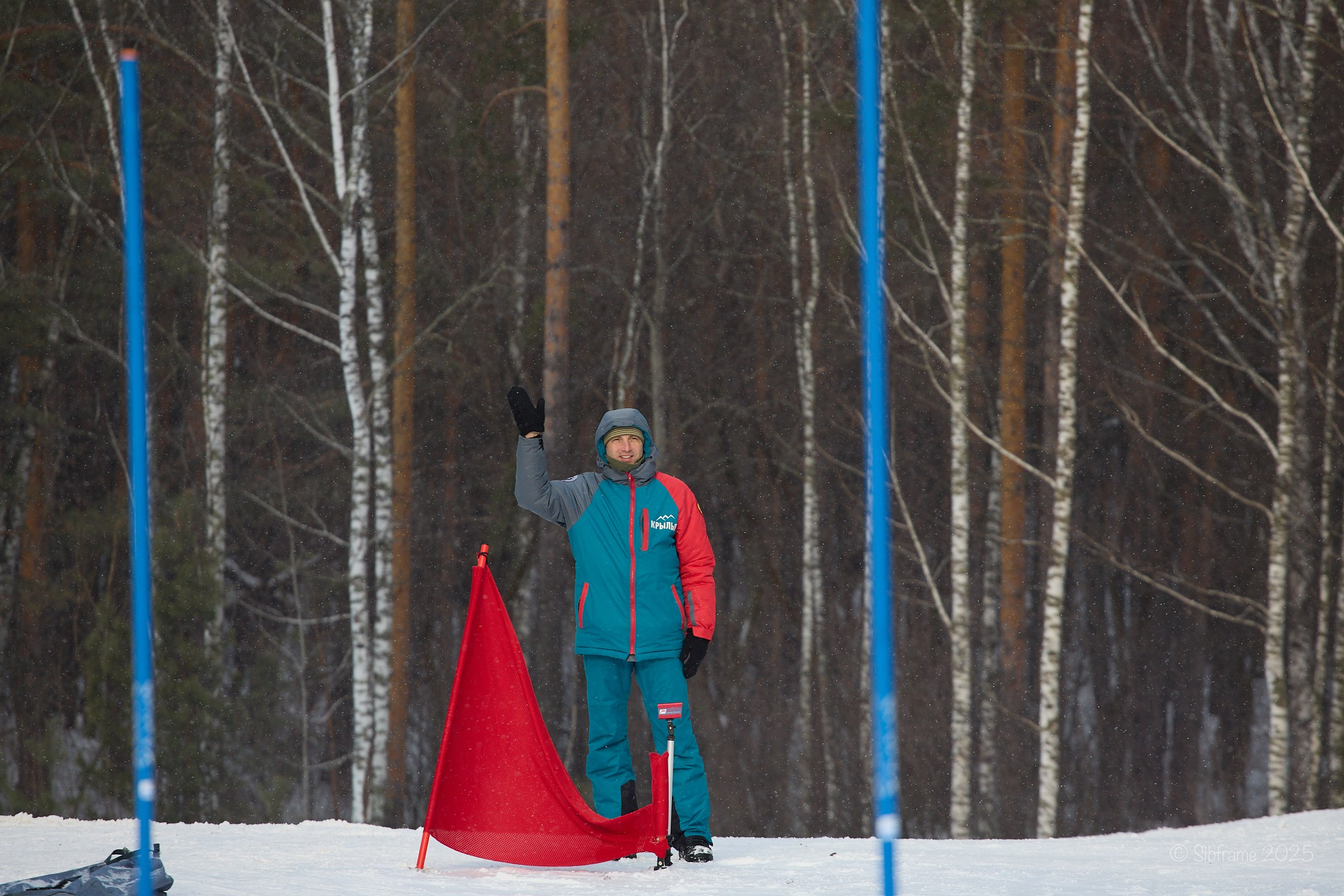 Судья из финишной зоны по ски-кроссу приветствует зрителей