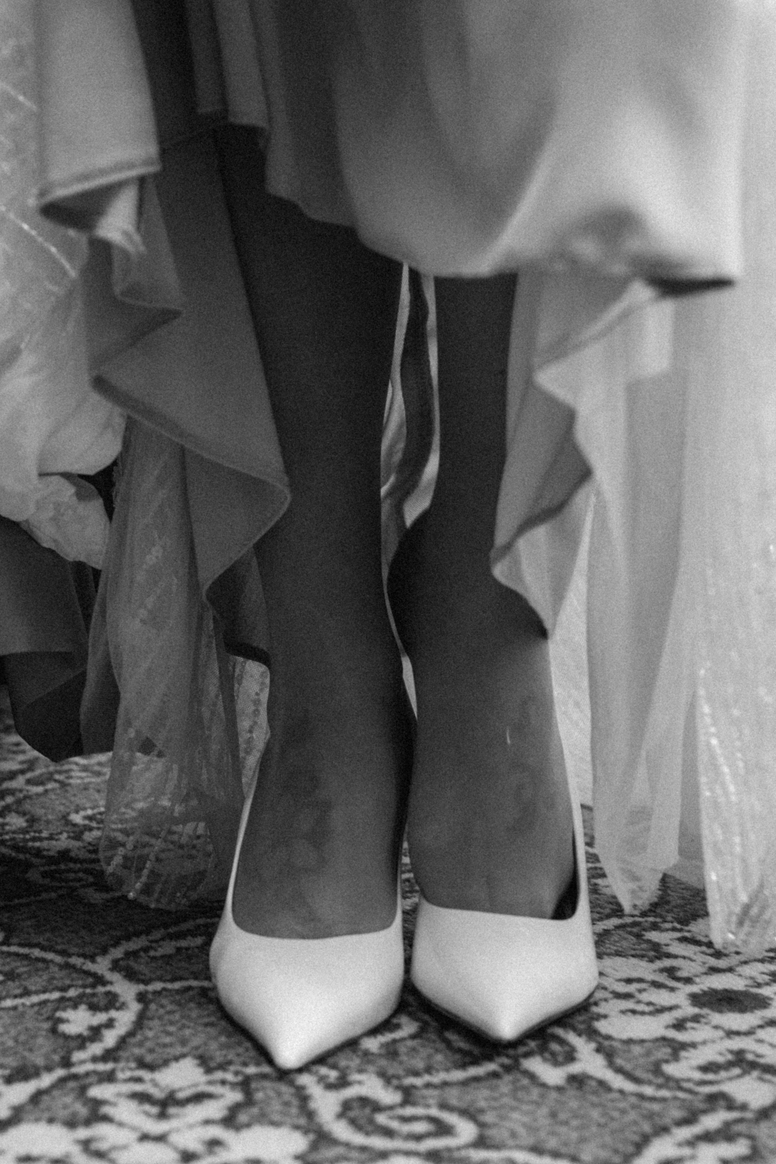 Невеста примеряет свадебные туфли в комнате с естественным светом — профессиональная фотосъемка подготовки к свадьбе в Москве.