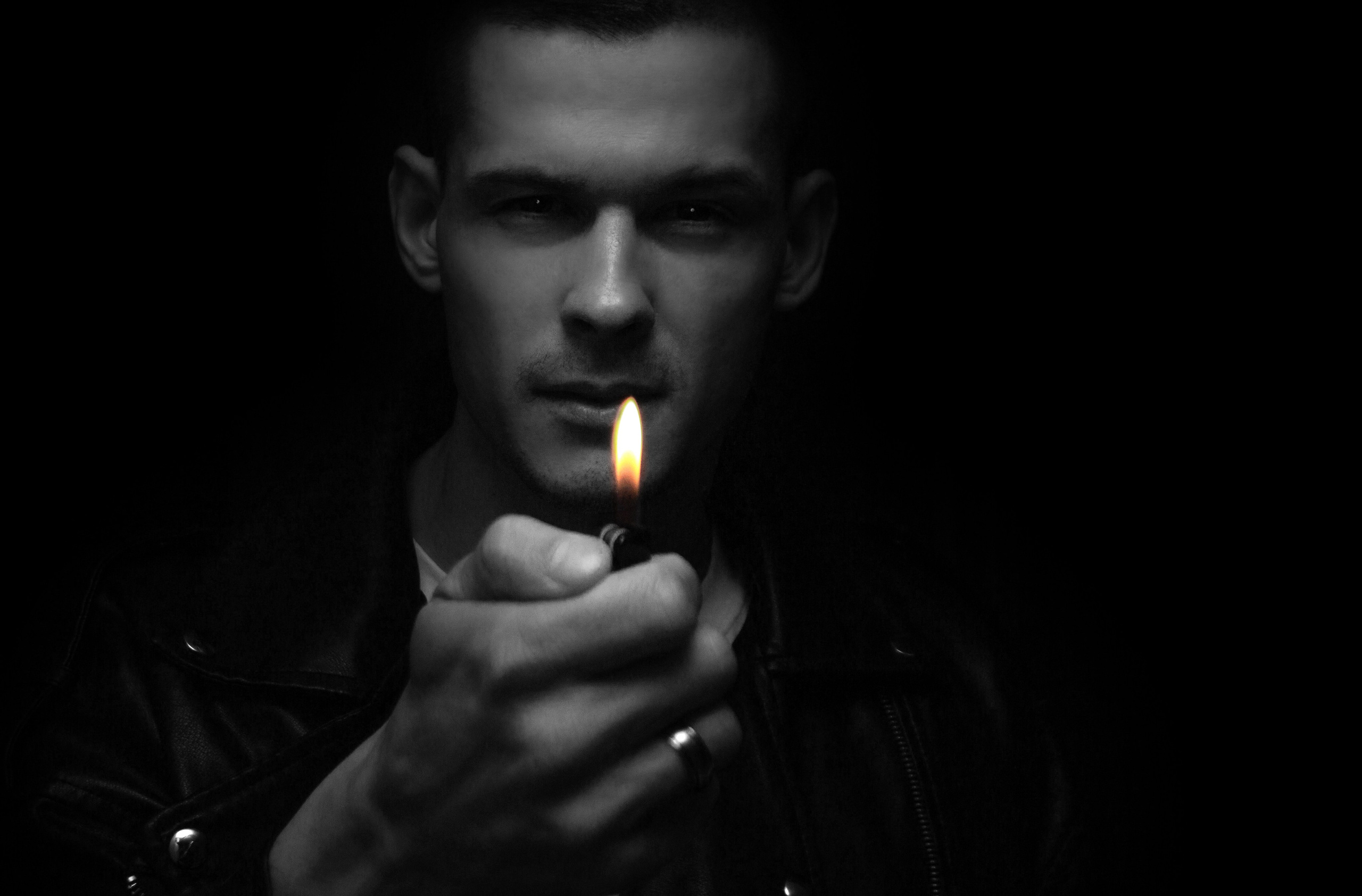 Человек с зажигалкой в темноте