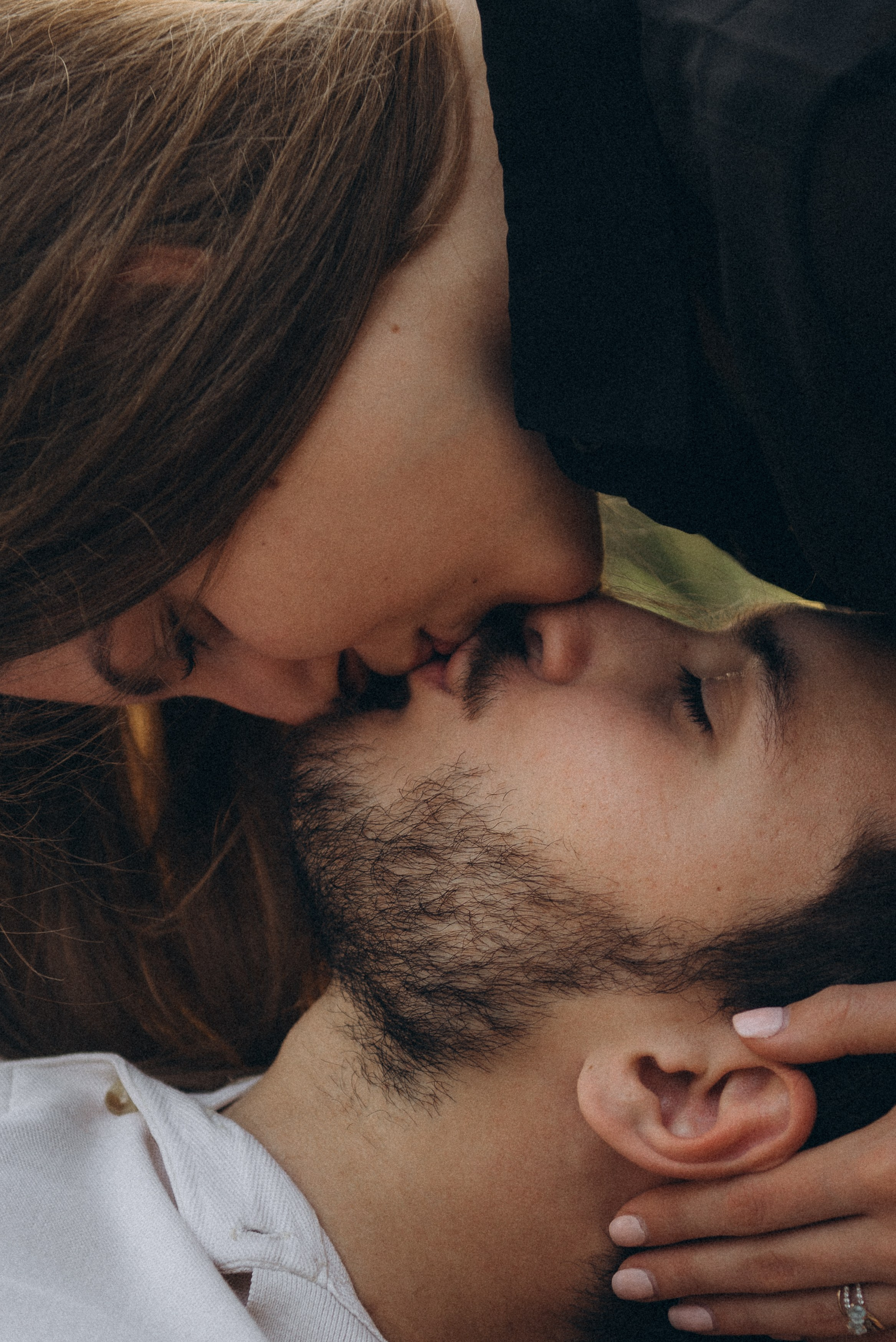 Вертикальный крупный план: нежный поцелуй влюбленной пары. Эстетичная съемка Love Story на Михайловской набережной.