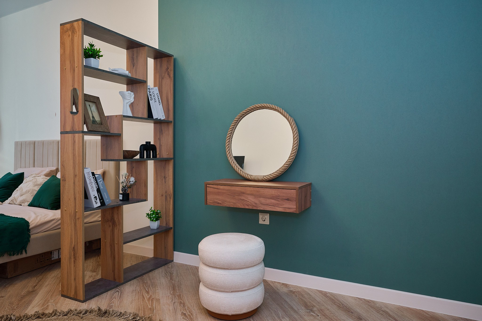 открытый темный шкаф круглое зеркало деревянная тумбочка и белый пуфик 