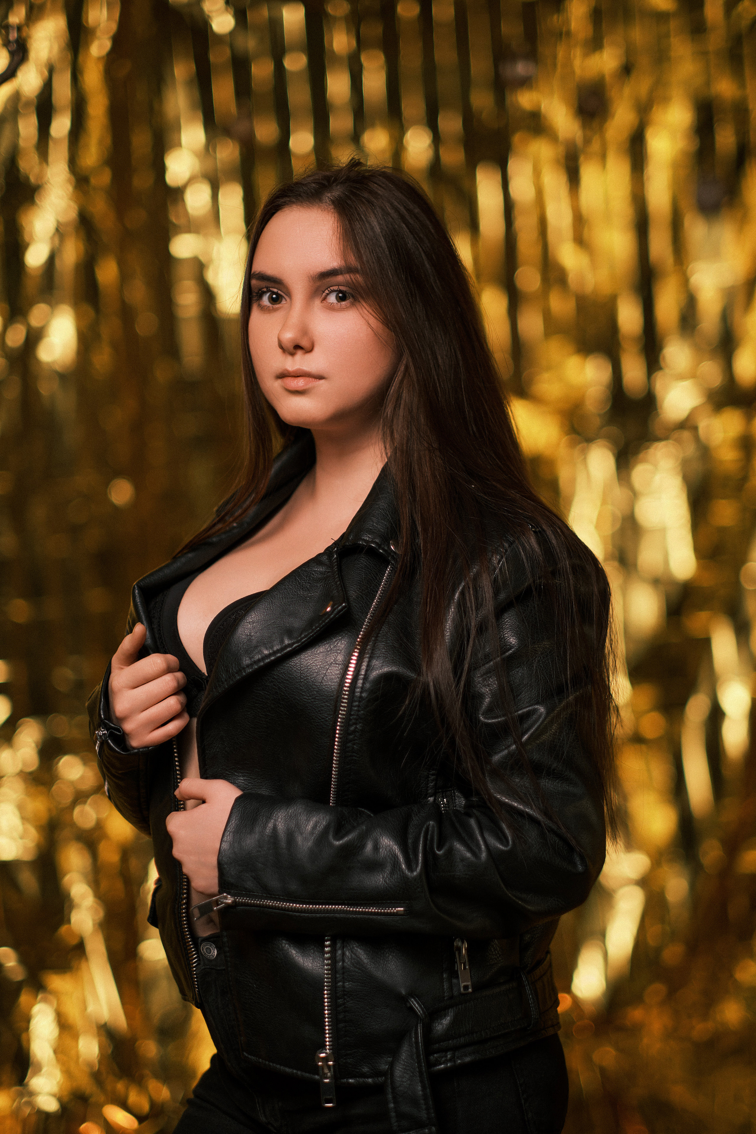 Алина - красивая молодая девушка, одетая в кожаную куртку и джинсы