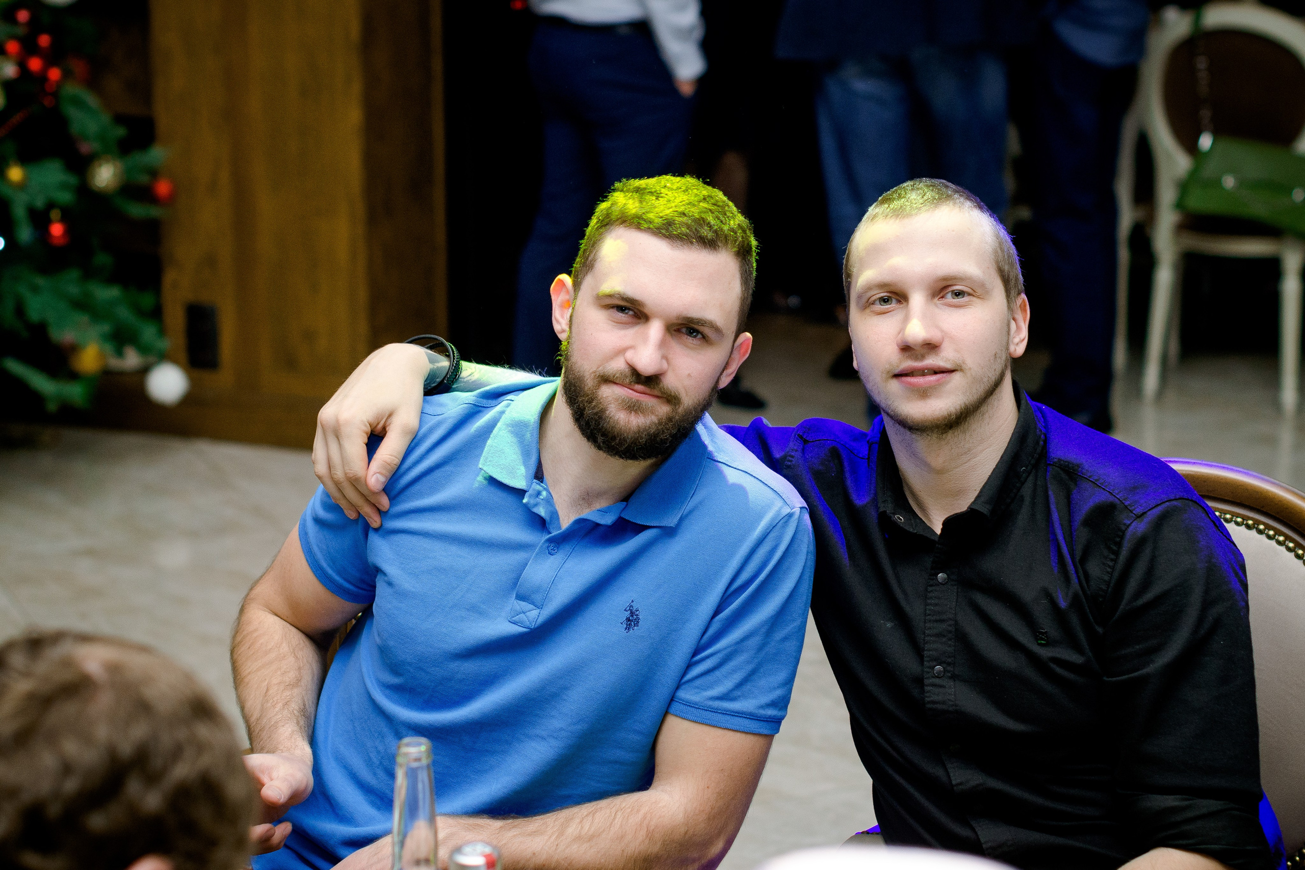 два молодых мужчины обнялись за праздничным столом