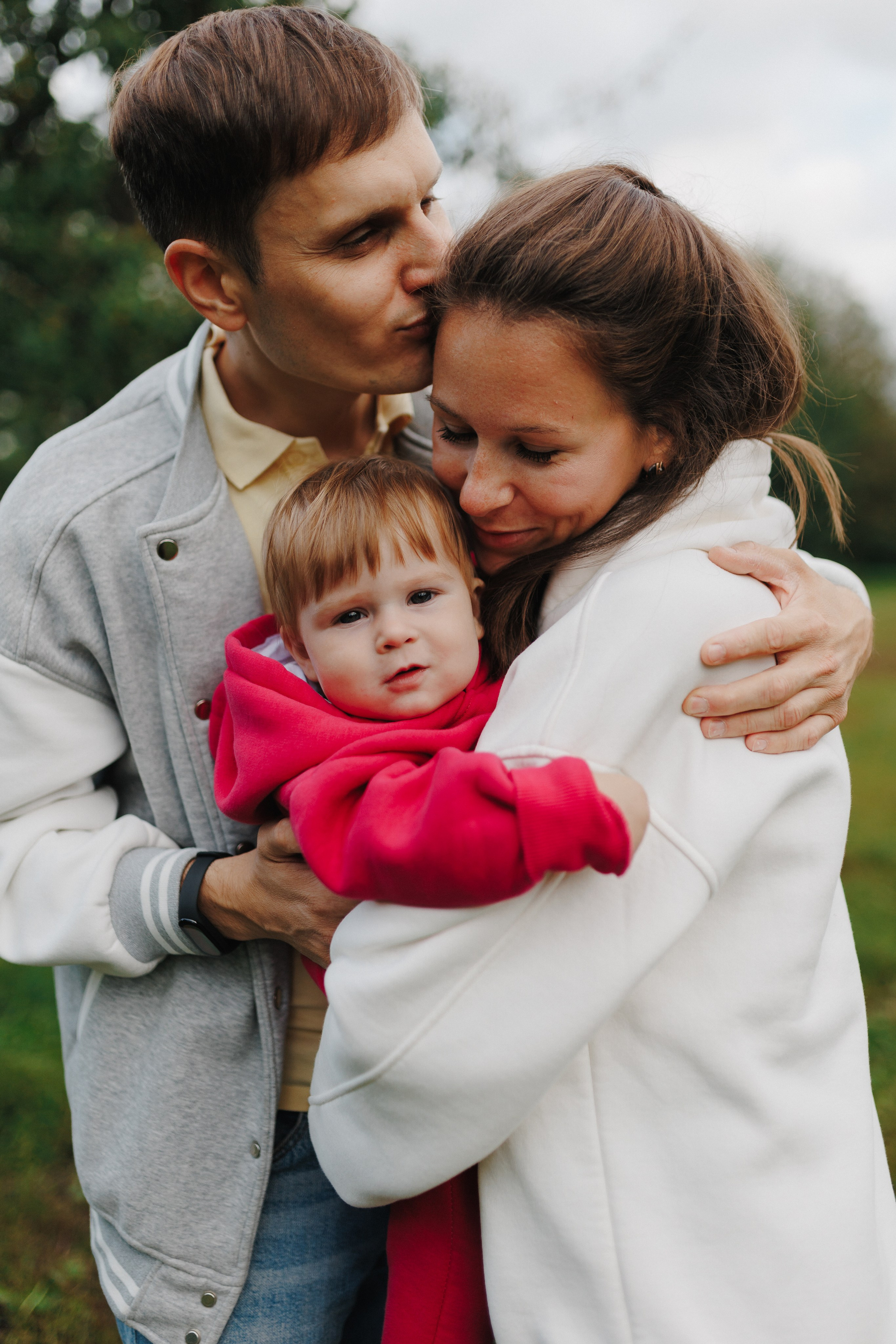 Счастливое трио: папа обнимает маму с ребёнком на руках. Семейная фотосессия с малышом на природе.