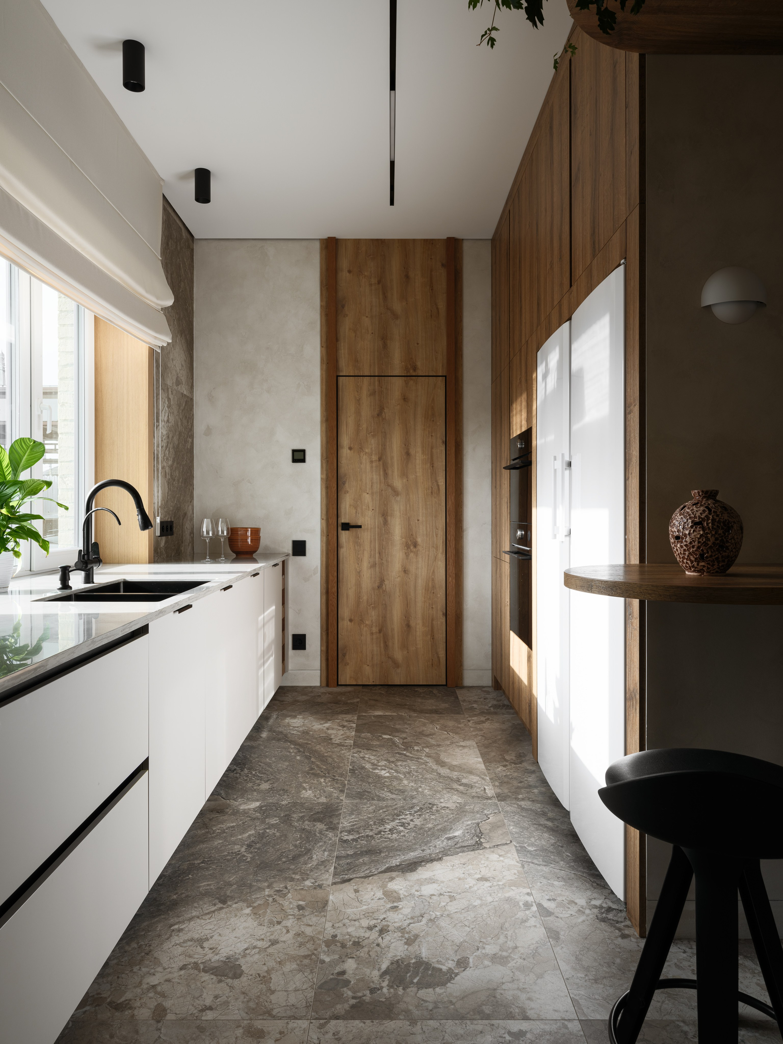 Интерьер современной кухни с натуральным деревом, каменными поверхностями и встроенной техникой. Дизайн Наталии Шелепниковой, фотосъёмка Сергея Денисенко и стилизация Алёны Бершацкой отражают гармонию природных материалов и функциональности.