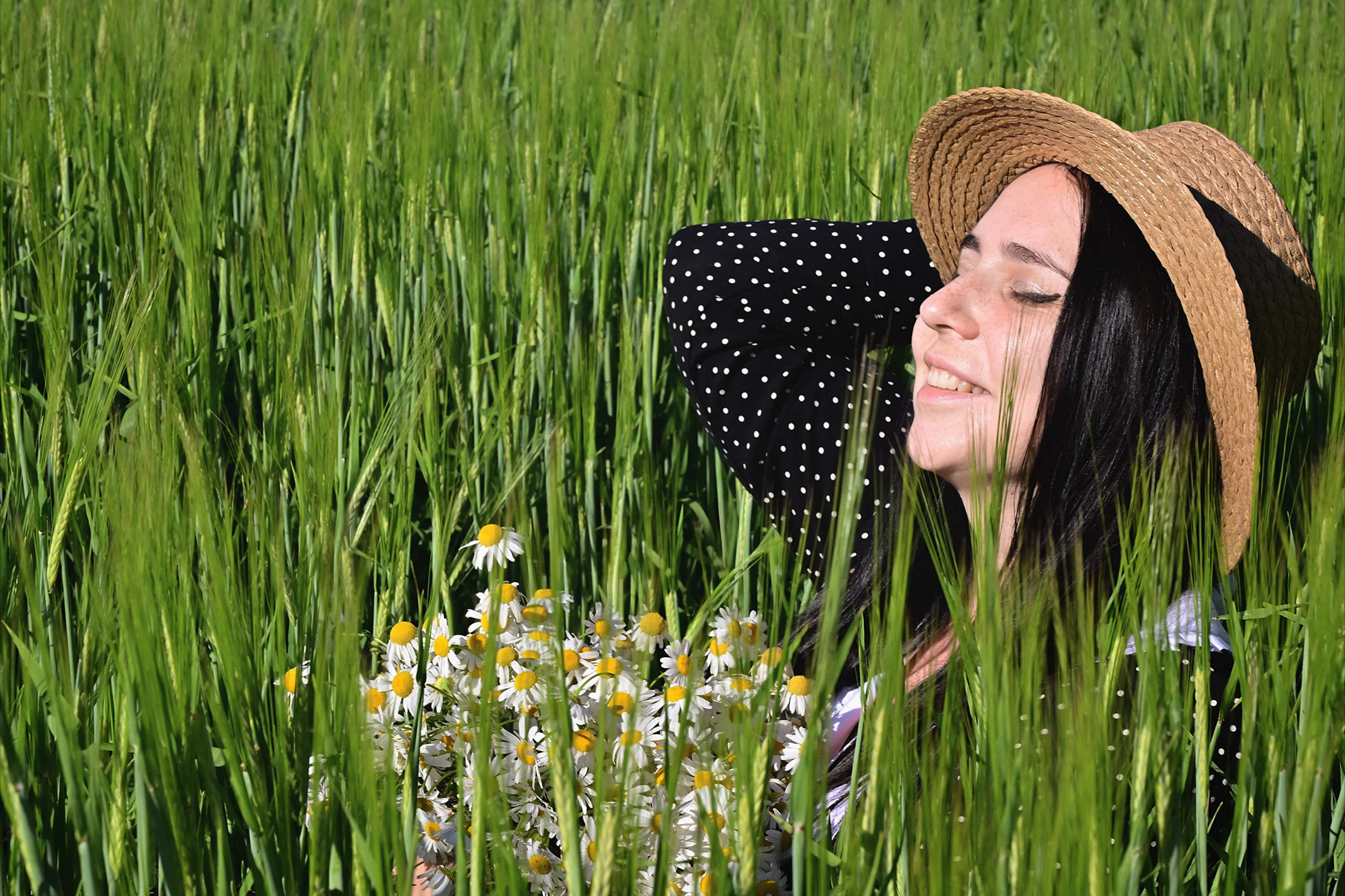 Девушка в шляпе с букетом ромашек