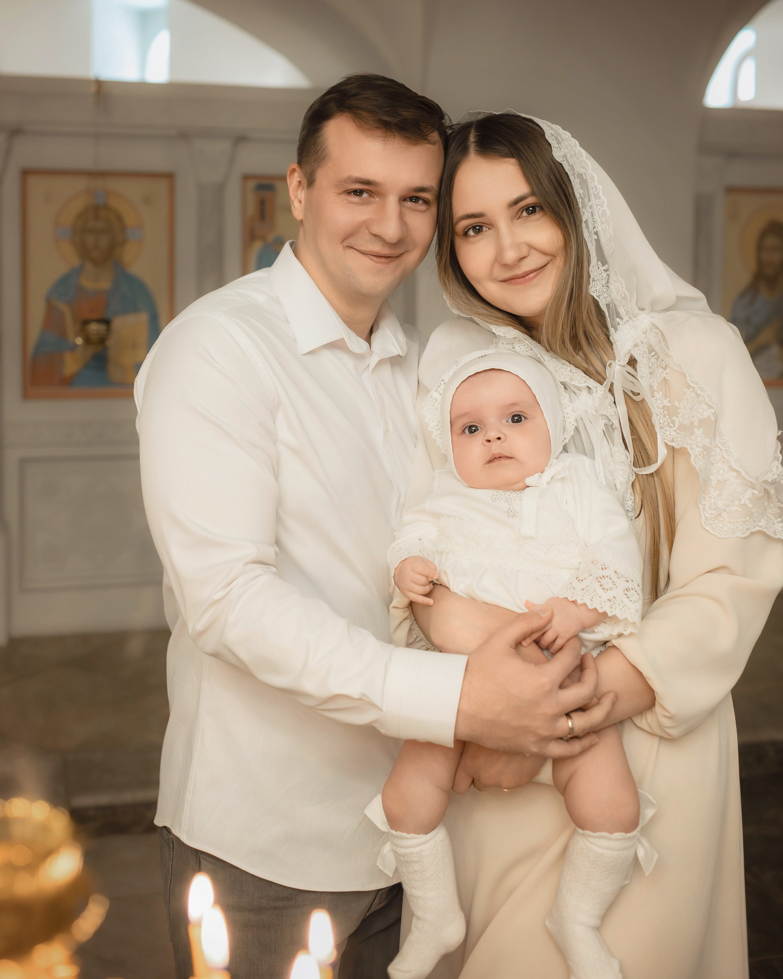 Родители с ребёнком в православном храме после крещения