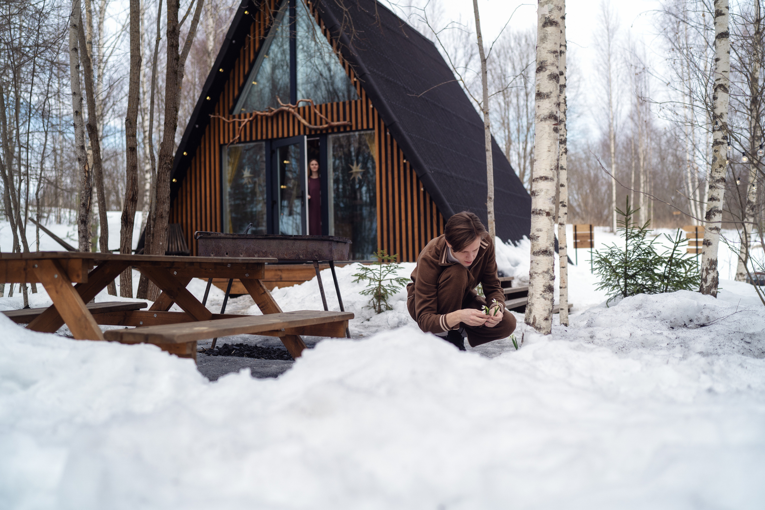 Молодой человек собирает подснежники в глэмпинге для своей любимой